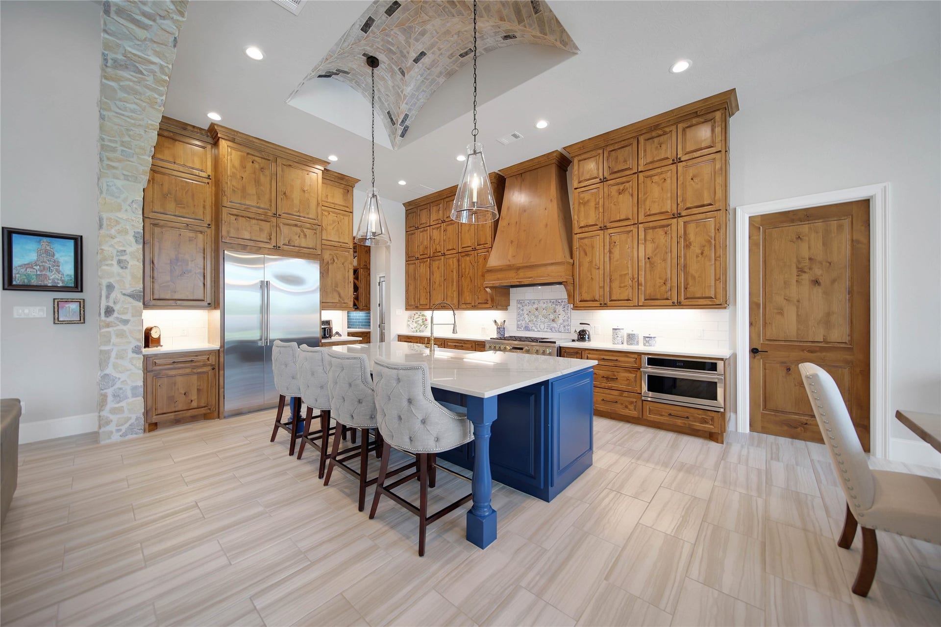 24718 Shadow Pond Drive, Spring, TX 77389 Spacious kitchen with elegant wood cabinetry, a striking blue island, and high-end stainless steel appliances, perfect for culinary enthusiasts.