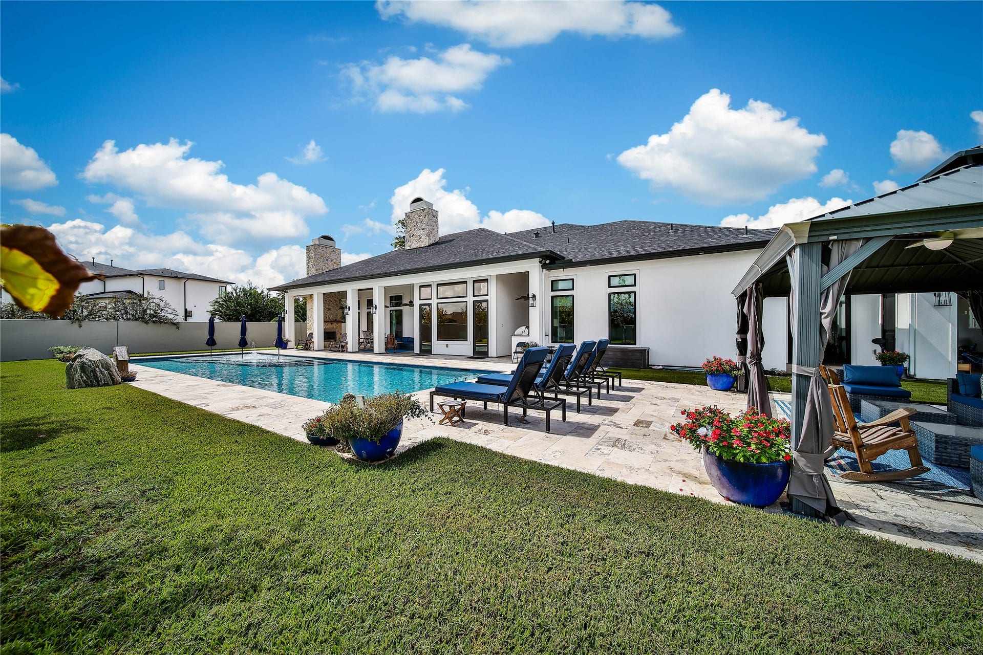 24718 Shadow Pond Drive, Spring, TX 77389 Luxurious outdoor oasis featuring a pristine pool, elegant patio seating, and a stylish gazebo, perfect for relaxation and entertaining.