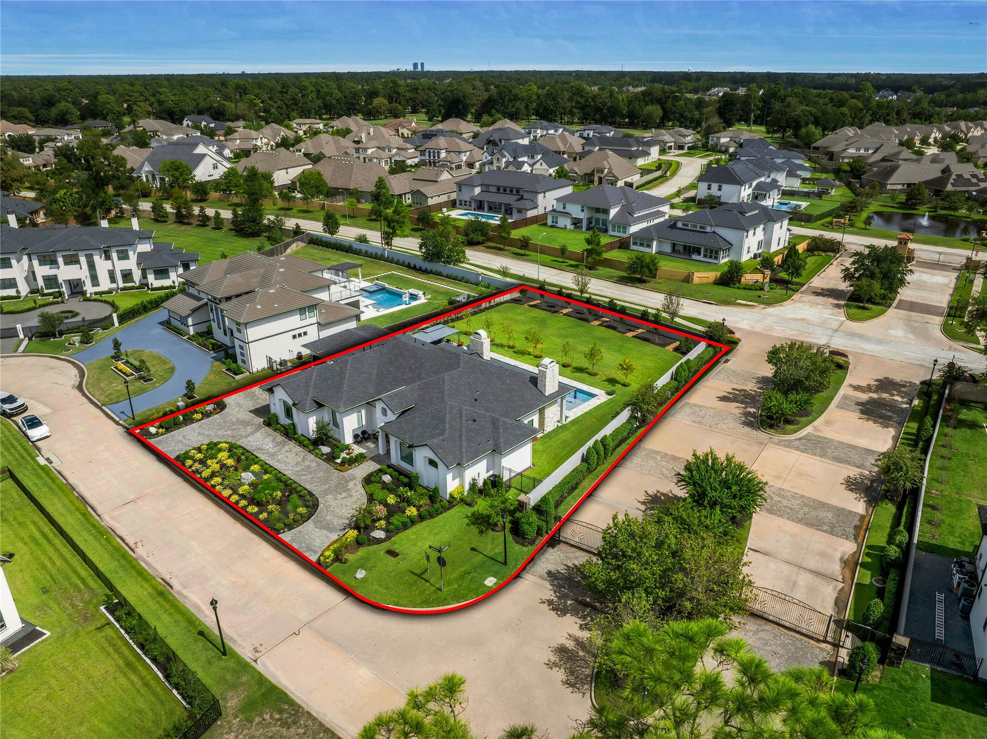 24718 Shadow Pond Drive, Spring, TX 77389 Spacious modern home on a well-manicured corner lot, featuring a private pool and lush landscaping in a picturesque neighborhood.