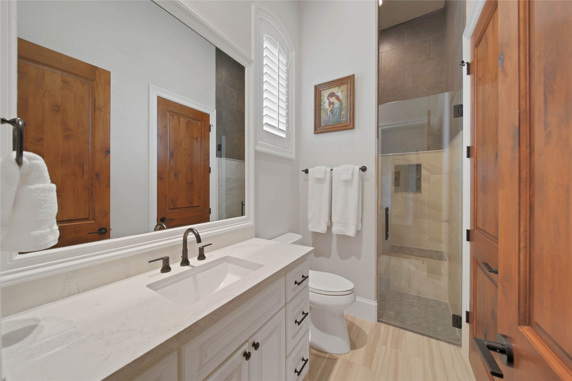 24718 Shadow Pond Drive, Spring, TX 77389 Elegant bathroom with a sleek vanity, modern fixtures, and a spacious glass-enclosed shower, complemented by warm wooden accents.