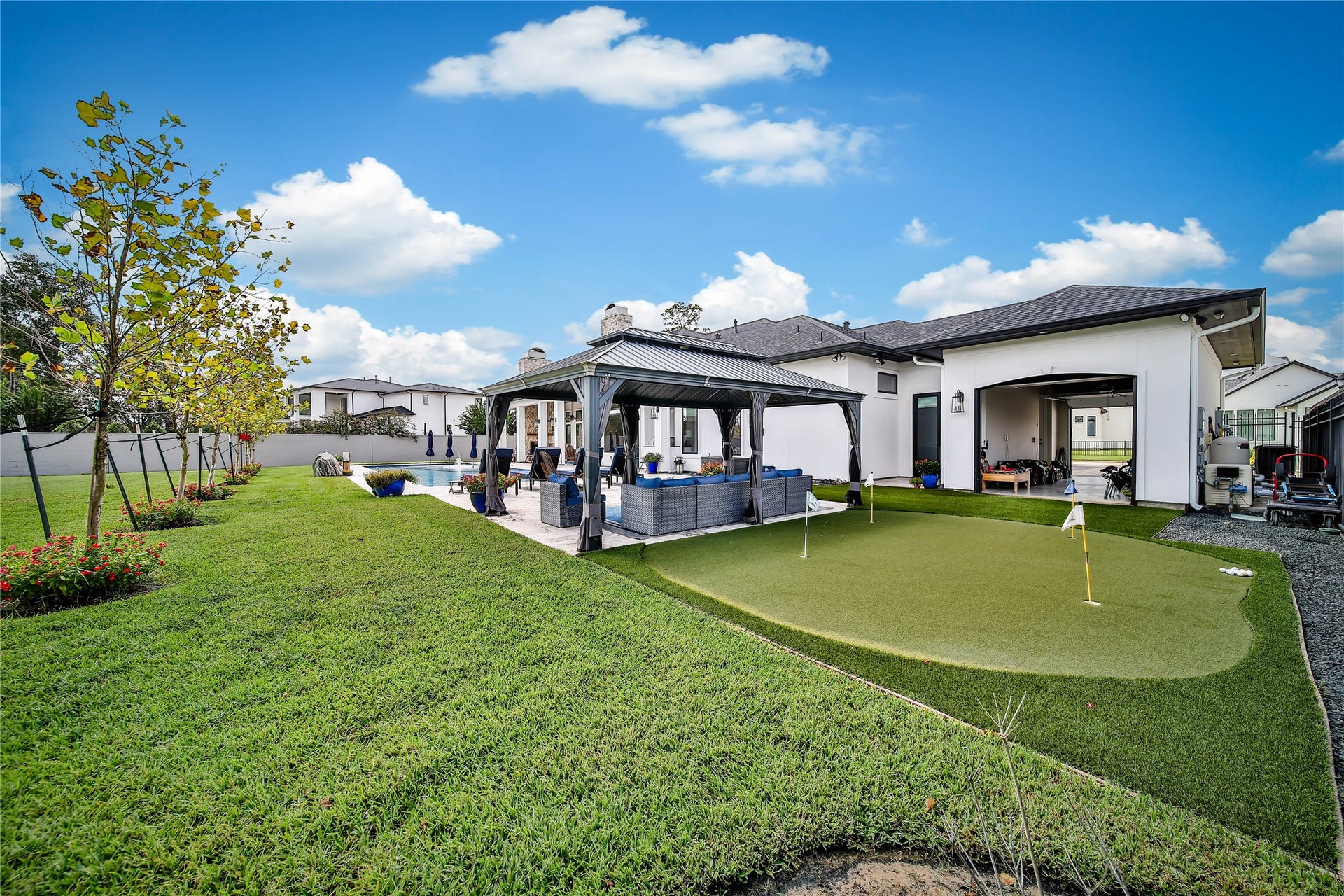 24718 Shadow Pond Drive, Spring, TX 77389 Expansive backyard features a charming gazebo, pristine putting green, and lush landscaping, perfect for relaxation and outdoor entertainment.