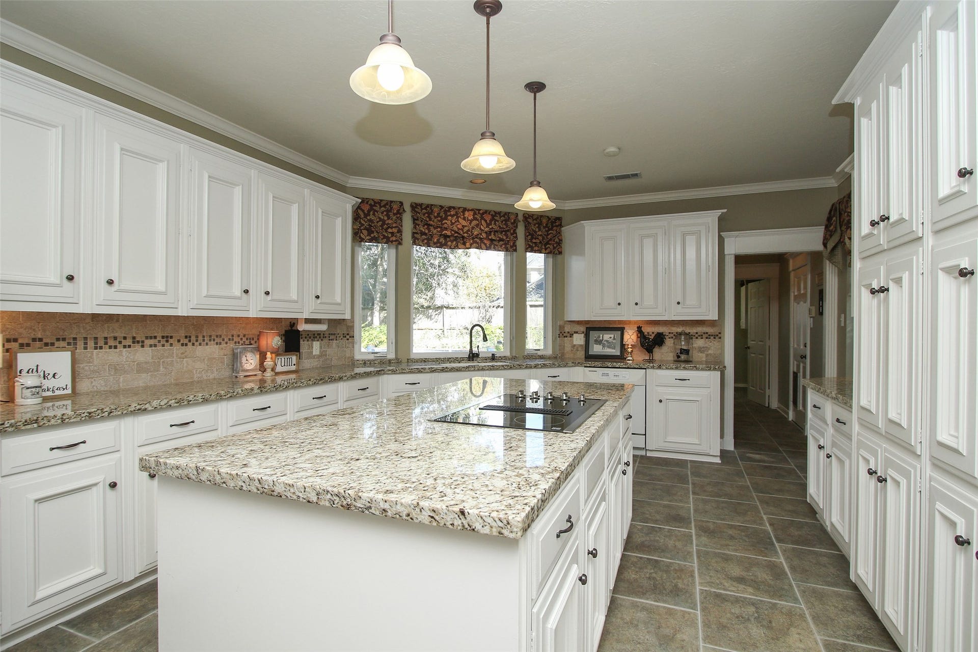 15914 Harwick Drive, Spring, TX 77379 KITCHEN WITH LARGE ISLAND with granite counters and tumbled marble back splash.