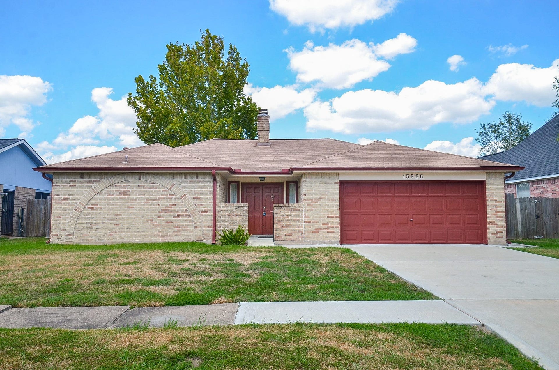 15926 Cardono Lane, Houston, TX 77489 Charming single-story brick home with a welcoming front entrance and spacious two-car garage, set on a well-sized lot with a beautiful tree in the background.
