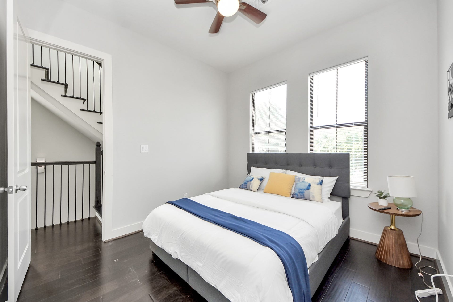 1706 Spring Street, Houston, TX 77007 Bright secondary bedroom with dark wood flooring, ceiling fan, and large windows.