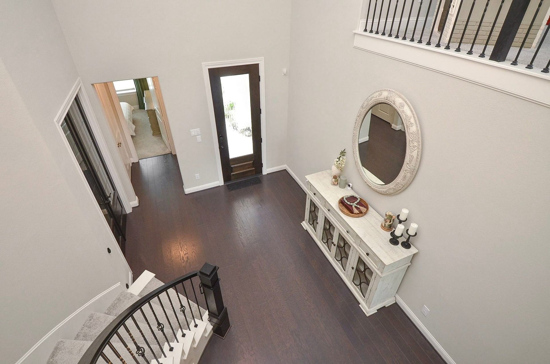 As you make your way back downstairs, take another moment to admire the elegant curved staircase and soaring two-story foyer.
