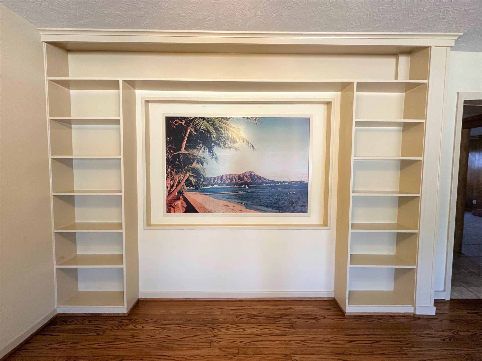 Fun mural in living room offering a tropical escape!  Niche would also be perfect place for big-screen TV.  Plenty of shelving for all your knick-knacks, books and photos.