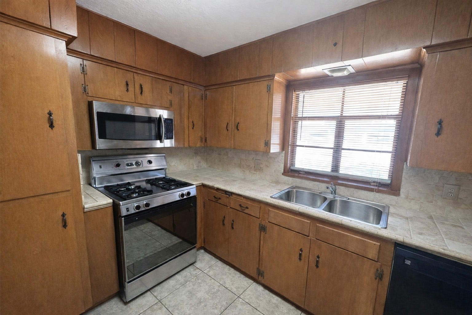 Kitchen with stainless gas range/4-burner cooktop, microwave, dishwasher, and stainless double-bowl sink.