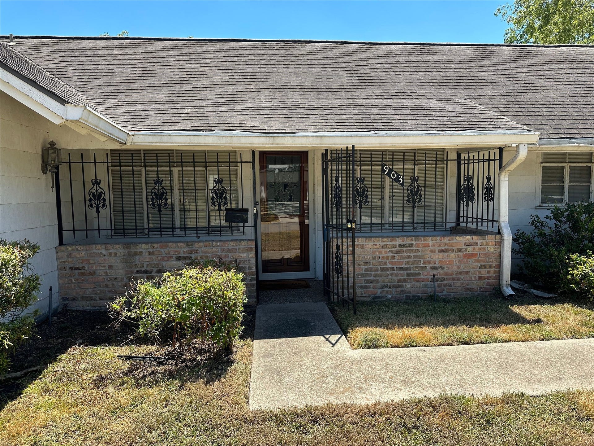 Front porch with locking iron gate and storm door.