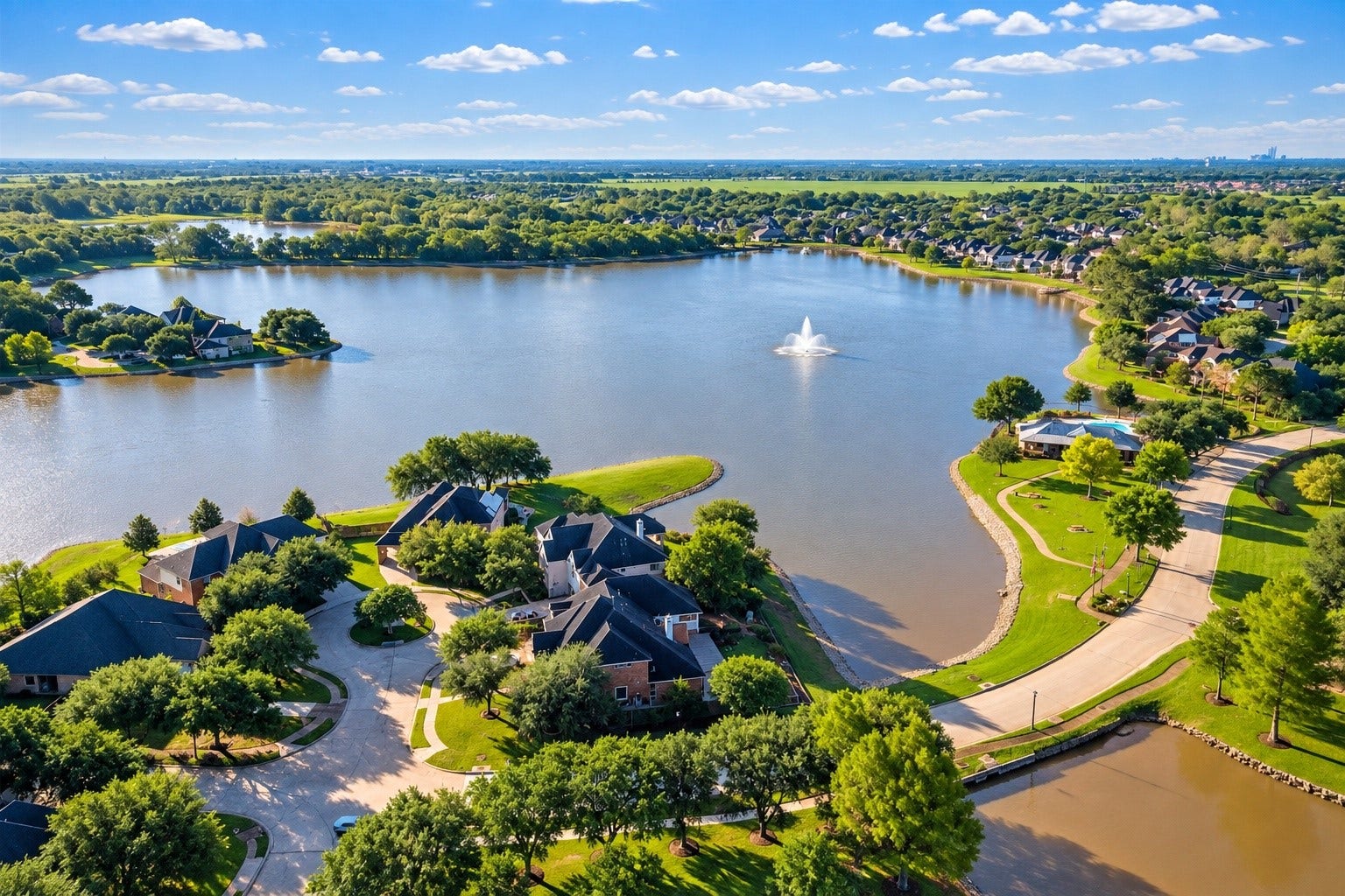 13611 Cottage Arbor Court, Sugar Land, TX 77498 Aerial view showcasing the communitys scenic lake, beautifully landscaped surroundings, walking paths, and peaceful residential setting.