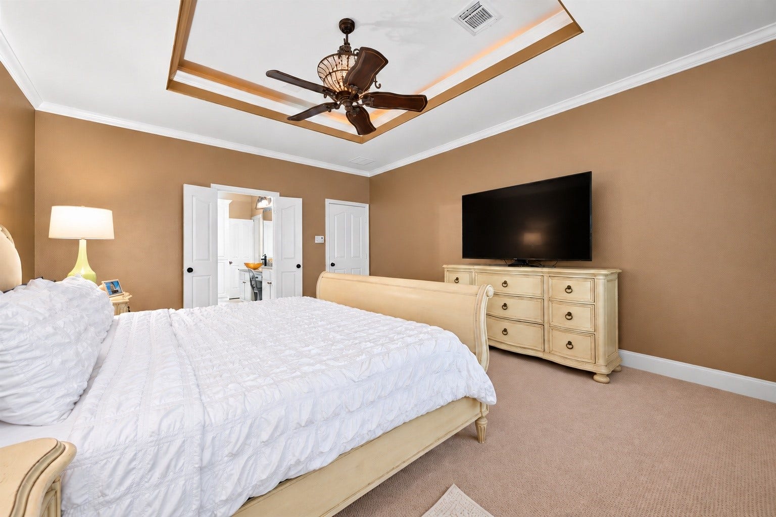 13611 Cottage Arbor Court, Sugar Land, TX 77498 Additional view of the primary suite showcases its generous proportions, elegant tray ceiling with accent lighting, and convenient access to the en-suite bath and closet.