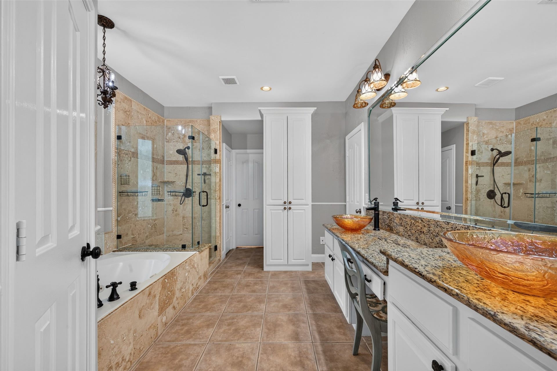 13611 Cottage Arbor Court, Sugar Land, TX 77498 Spacious primary bath showcases a jetted soaking tub, separate glass-enclosed walk-in shower, dual vessel sinks with granite countertops, and generous built-in storage