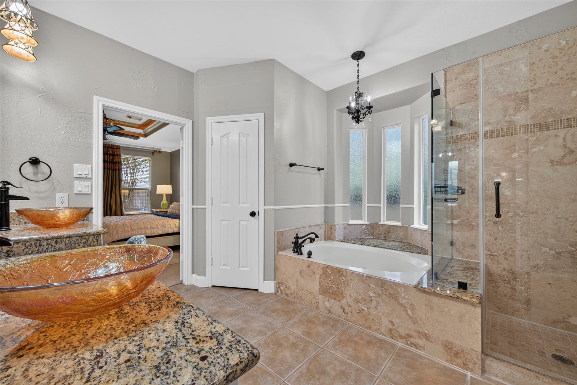 13611 Cottage Arbor Court, Sugar Land, TX 77498 Spa-inspired primary bath featuring dual vessel sinks, granite countertops, a soaking tub, and a spacious walk-in shower with beautiful stone and tile detailing.