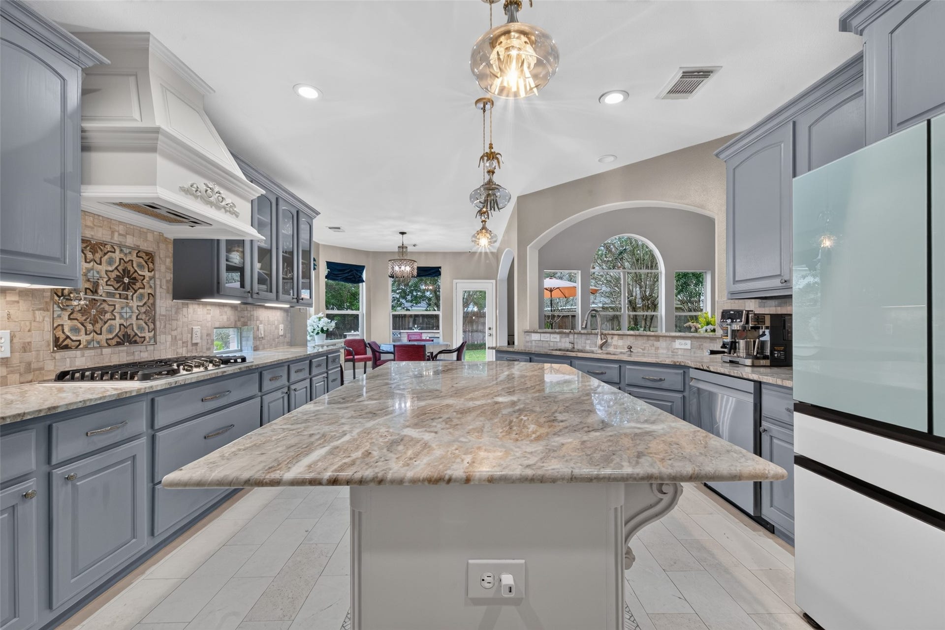 13611 Cottage Arbor Court, Sugar Land, TX 77498 Expansive center island with beautifully detailed stone countertops provides generous prep space and serves as a striking centerpiece to this spacious kitchen.