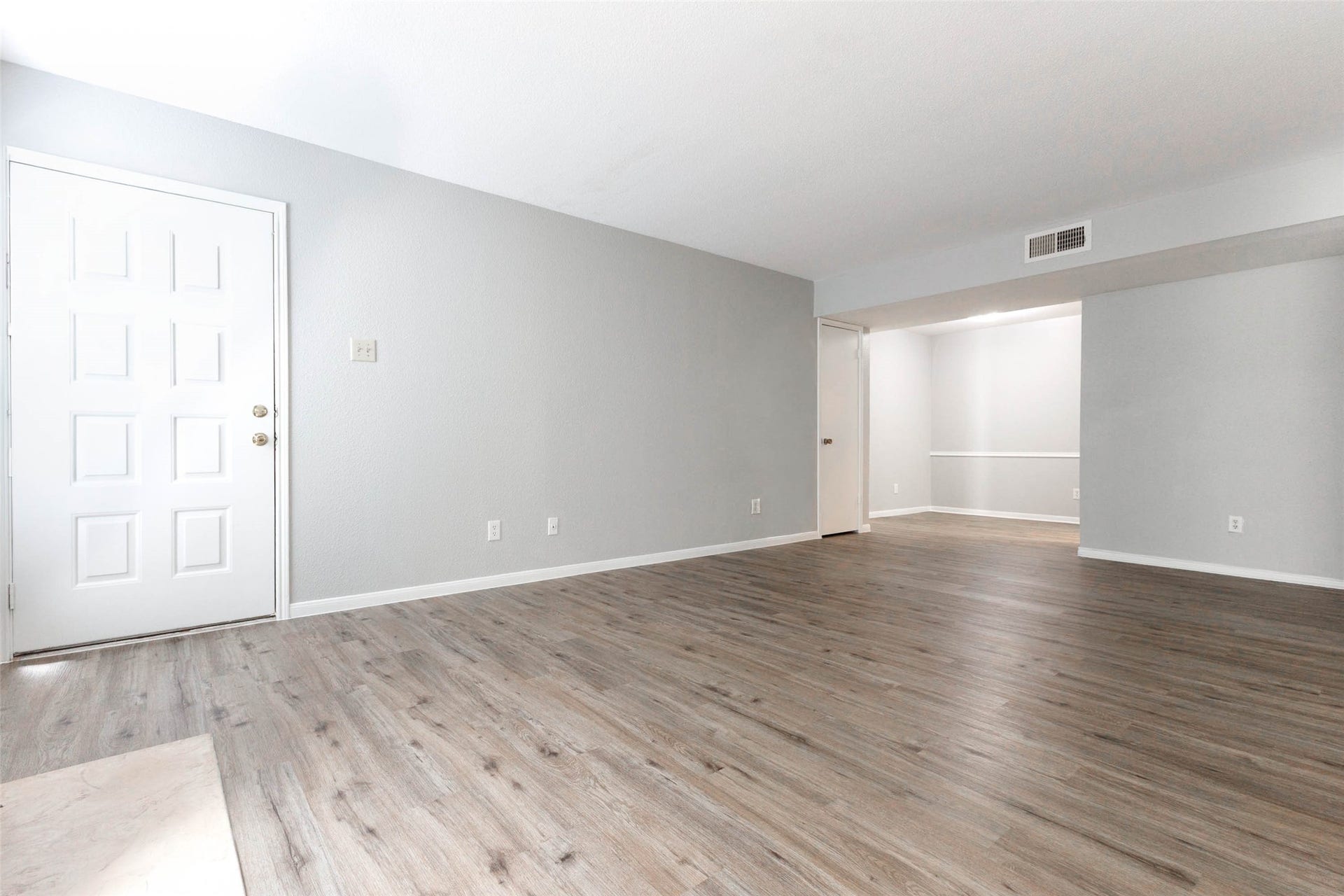 Wide-angle view showcasing the generous living space and seamless connection to the adjoining dining area.