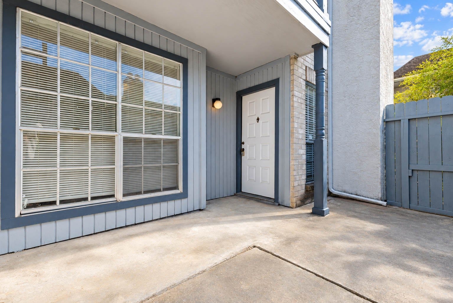 Private enclosed patio with concrete flooring, offering a convenient outdoor space for relaxing or enjoying fresh air.