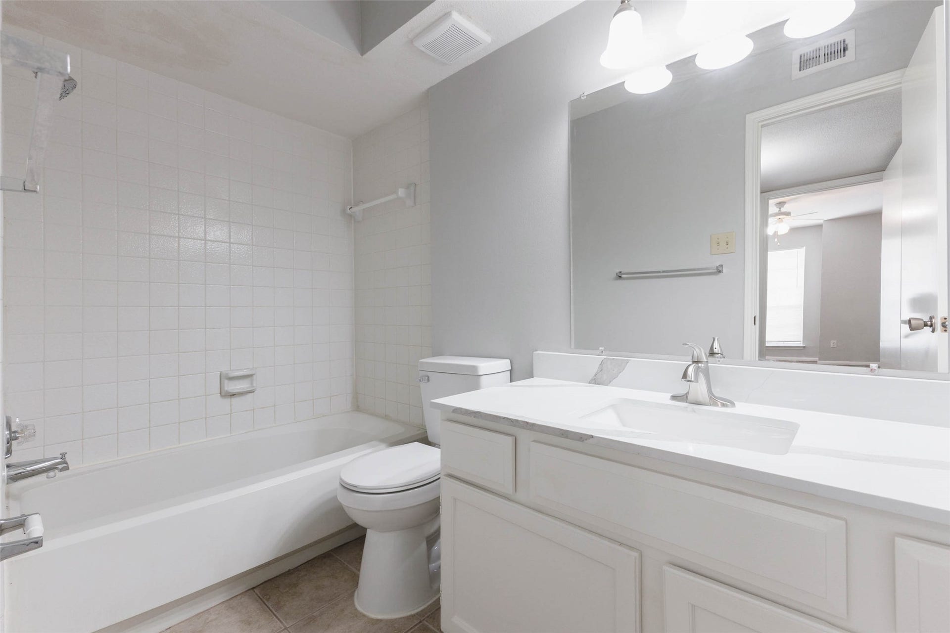 Full bathroom featuring a vanity with cabinet storage, large mirror, and tub/shower combination.