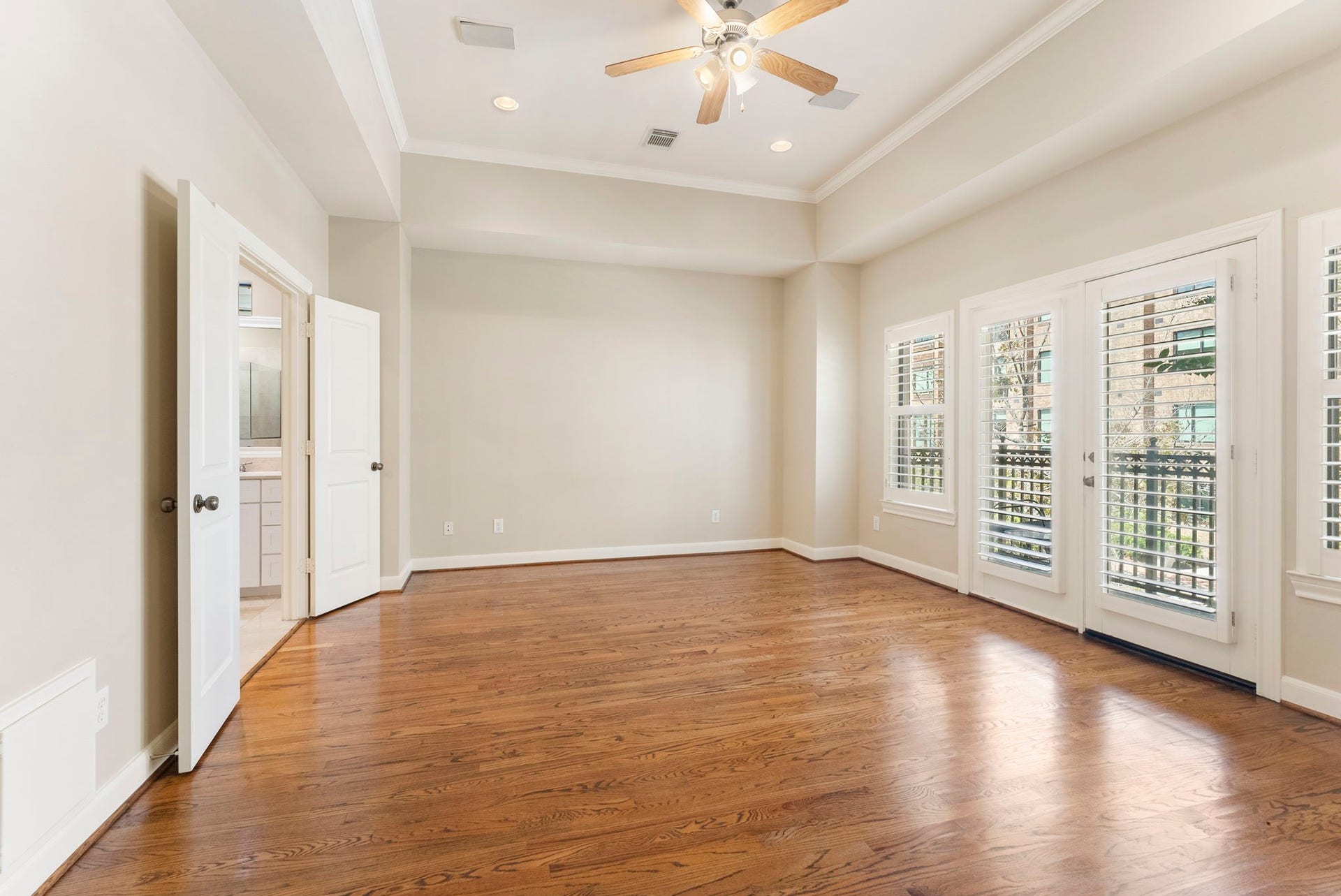 24 Riva Row, Spring, TX 77380 Hardwood floors, a tray ceiling, and and built-in niche.abundant natural light make the primary bedroom feel open and airy.