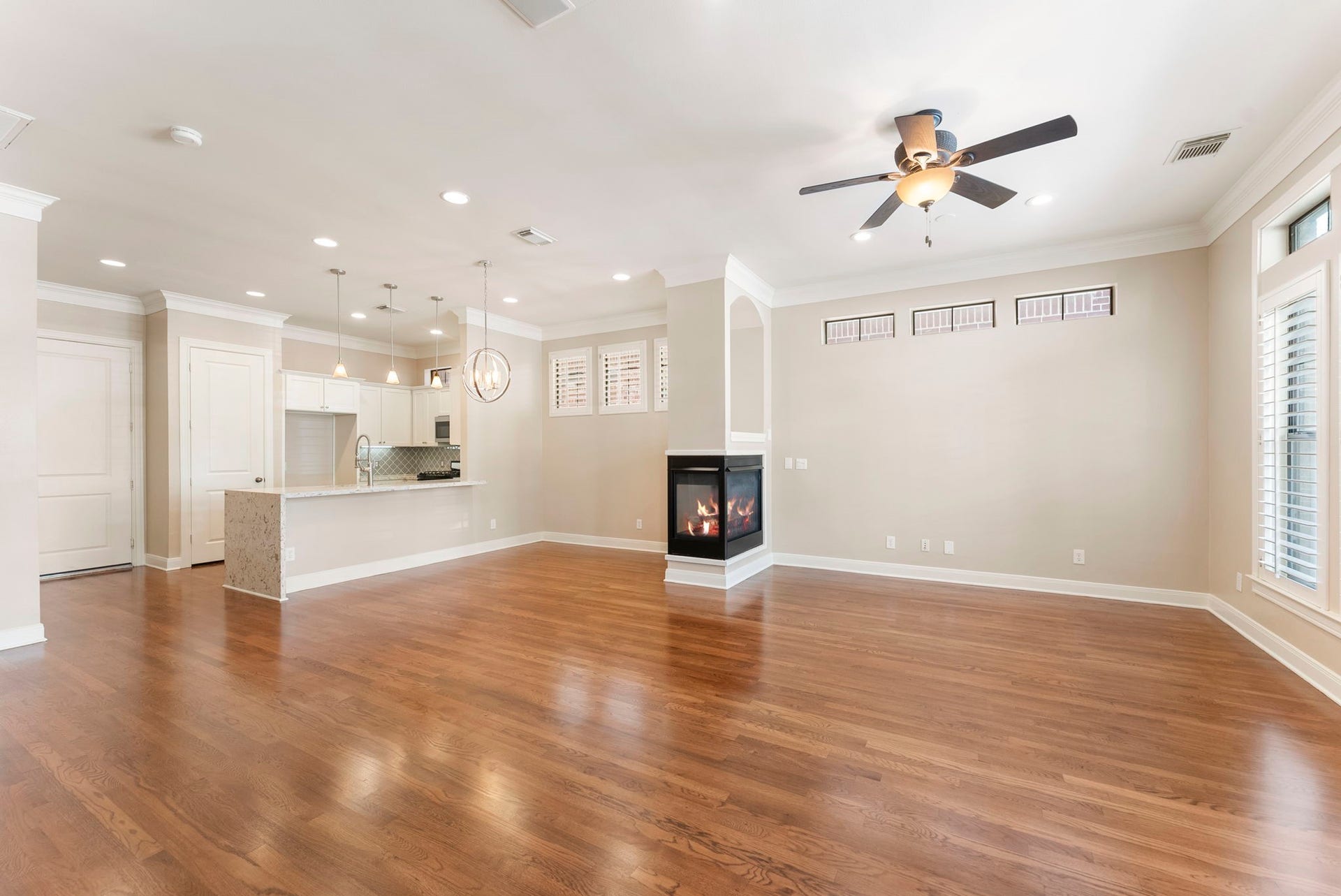 24 Riva Row, Spring, TX 77380 Wide open and full of light, with a waterfall-edge island and three-sided fireplace tying the space together.