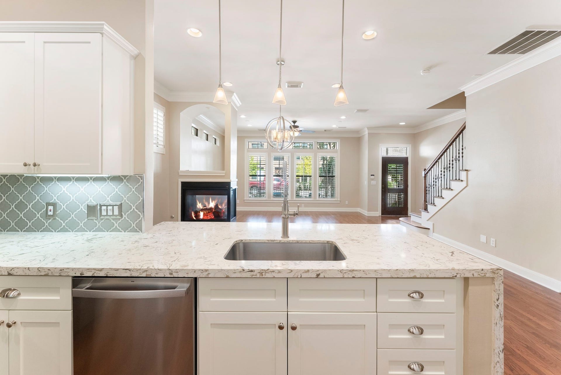 24 Riva Row, Spring, TX 77380 Quartz countertops, an undermount sink, and pendant lighting with a full view of the main level.