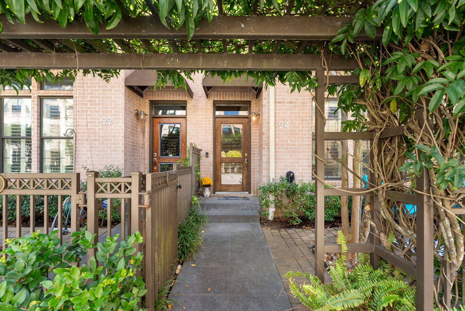 24 Riva Row, Spring, TX 77380 A gated entry beneath a lush pergola opens to the private courtyard of 24 Riva Row.