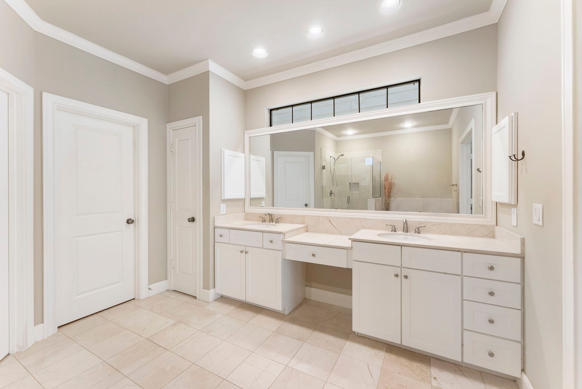 24 Riva Row, Spring, TX 77380 Dual sinks, a built-in makeup vanity, and a wide framed mirror make getting ready a breeze.
