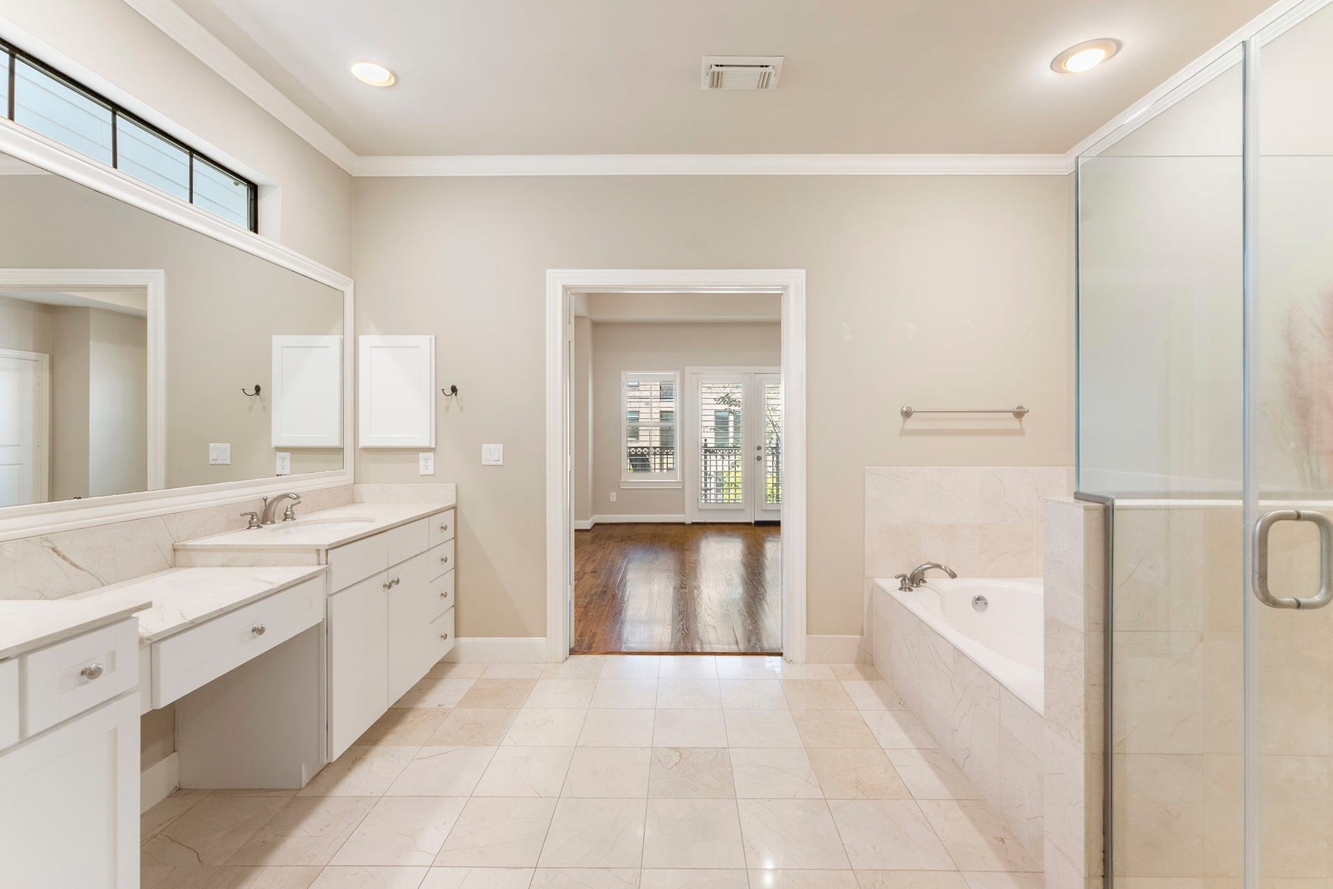 24 Riva Row, Spring, TX 77380 Double vanities with a makeup station sit across from the soaking tub.