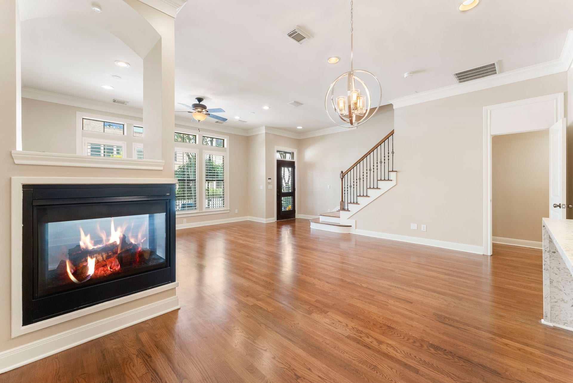 24 Riva Row, Spring, TX 77380 Looking from the dining area toward the front door, the see-through fireplace gently defines the space without closing it off.