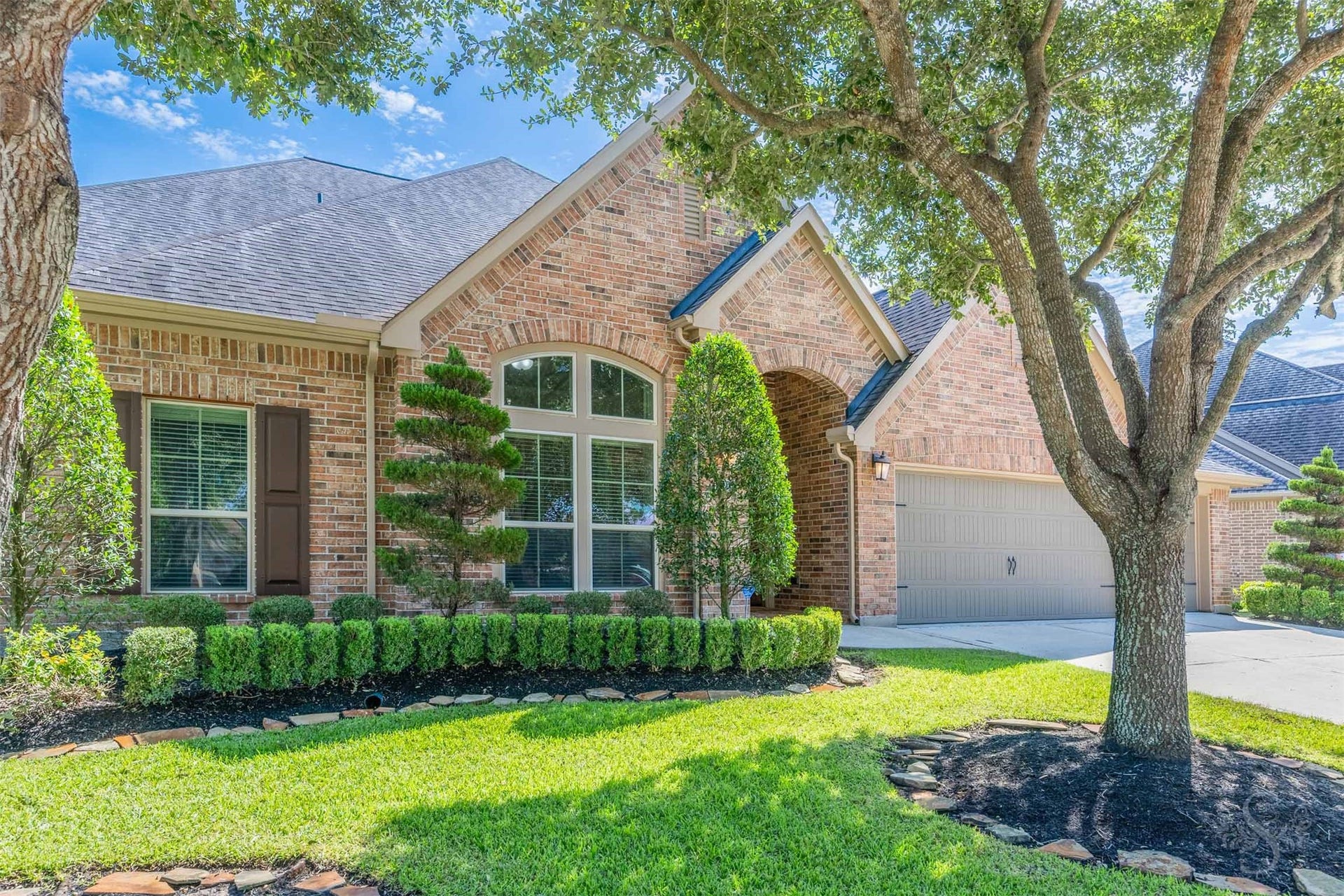 5219 Kenton Place Lane, Fulshear, TX 77441 Graceful rooflines & intricate brick detailing give this Perry home an impressive presence along the tree-lined street. Sculpted evergreens & neatly bordered garden beds complement the classic architecture, creating an elegant welcome.