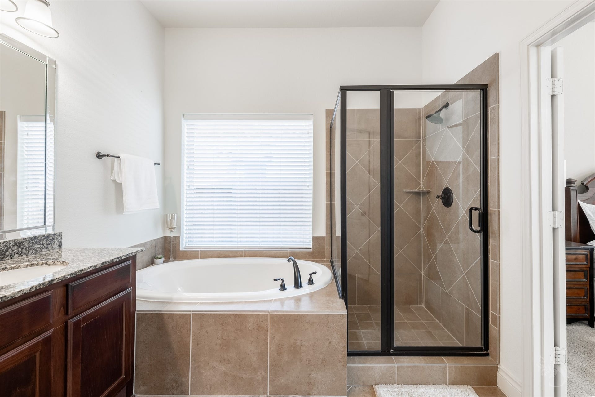 5219 Kenton Place Lane, Fulshear, TX 77441 Unwind with a leisurely soak in the garden tub, nestled beneath a large window in the primary bath. A separate glass-enclosed shower and generous granite vanity complete this comfortable personal retreat.