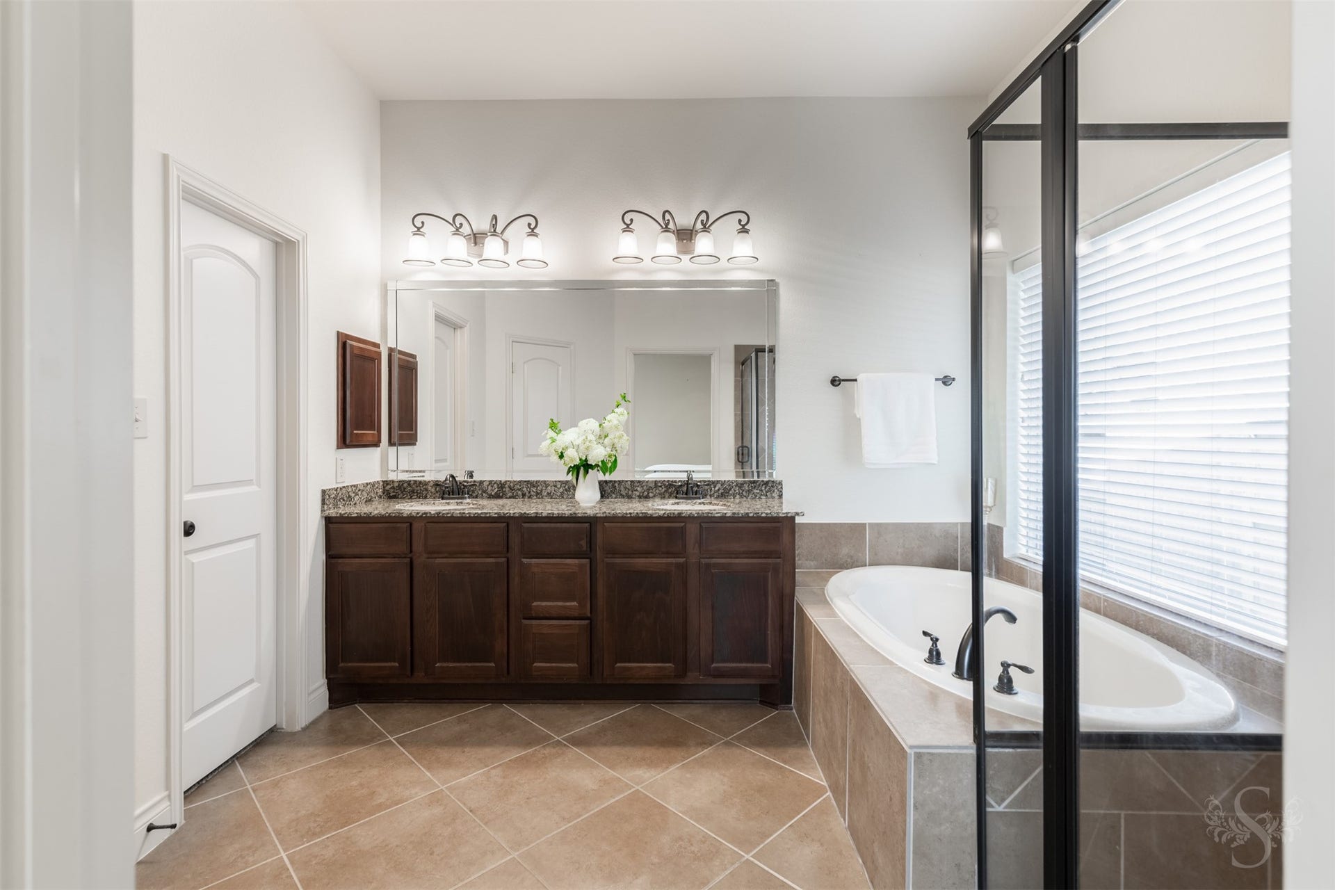 5219 Kenton Place Lane, Fulshear, TX 77441 The spacious primary bath pairs a granite vanity with dual sinks and rich cabinetry for an elegant start to your daily routine. A garden tub and separate glass-enclosed shower offer inviting options for relaxation and refreshment.