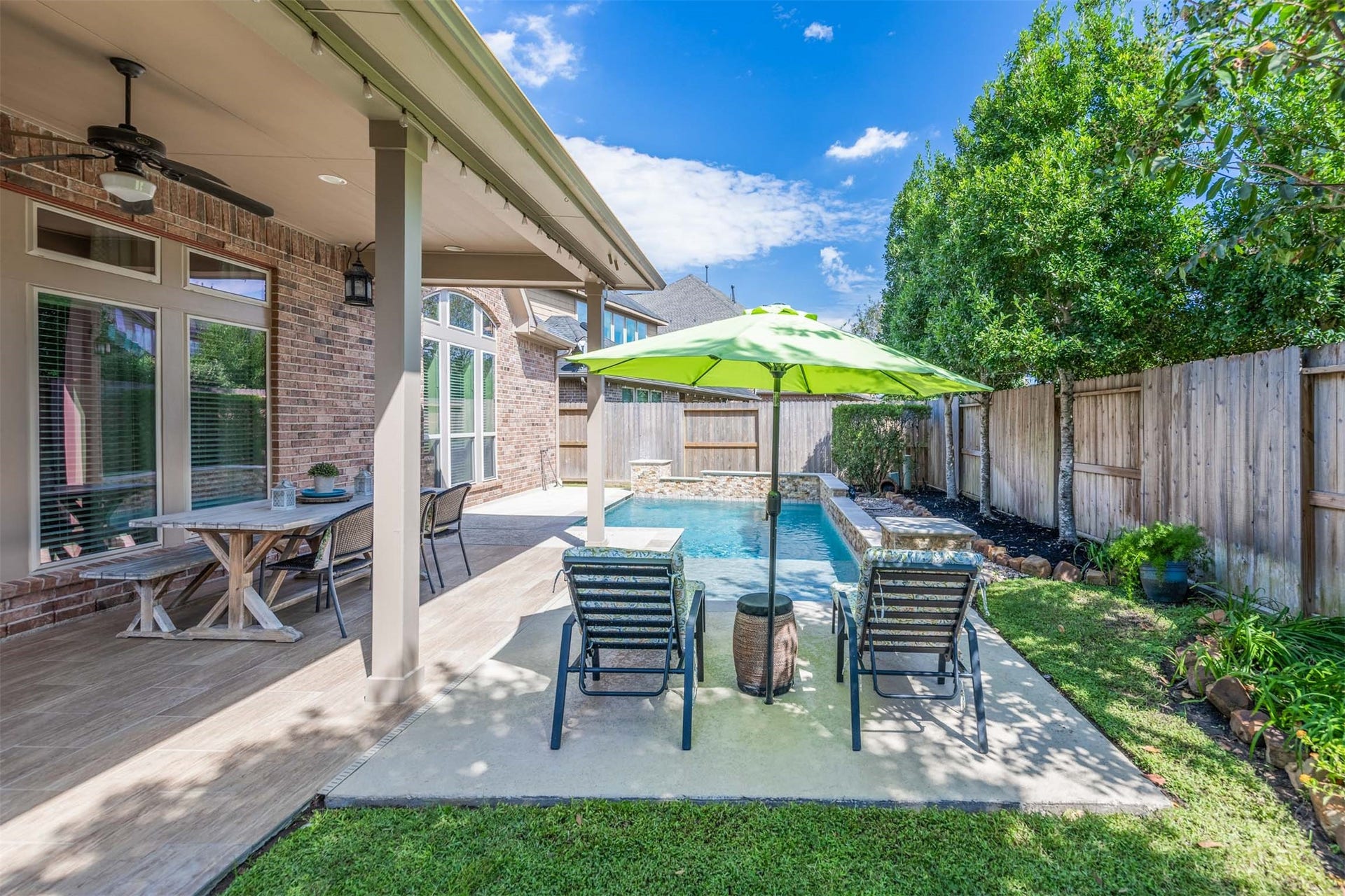 5219 Kenton Place Lane, Fulshear, TX 77441 Enjoy a refreshing swim before settling into a favorite lounge chair in this beautifully landscaped backyard oasis. Mature trees and lush garden beds create a picturesque setting for leisurely afternoons by the pool.