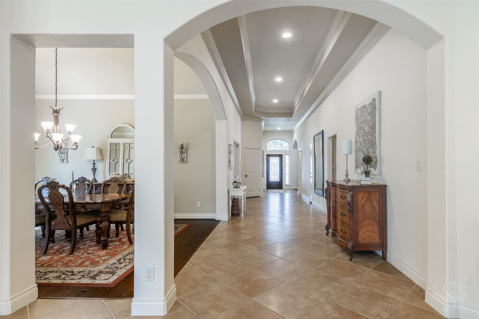 5219 Kenton Place Lane, Fulshear, TX 77441 Graceful archways frame the formal dining room and extended entry, highlighting the architectural beauty that carries throughout the home. An elongated tray ceiling with crown molding and recessed lighting adds an exquisite finishing touch to this welcoming passage.