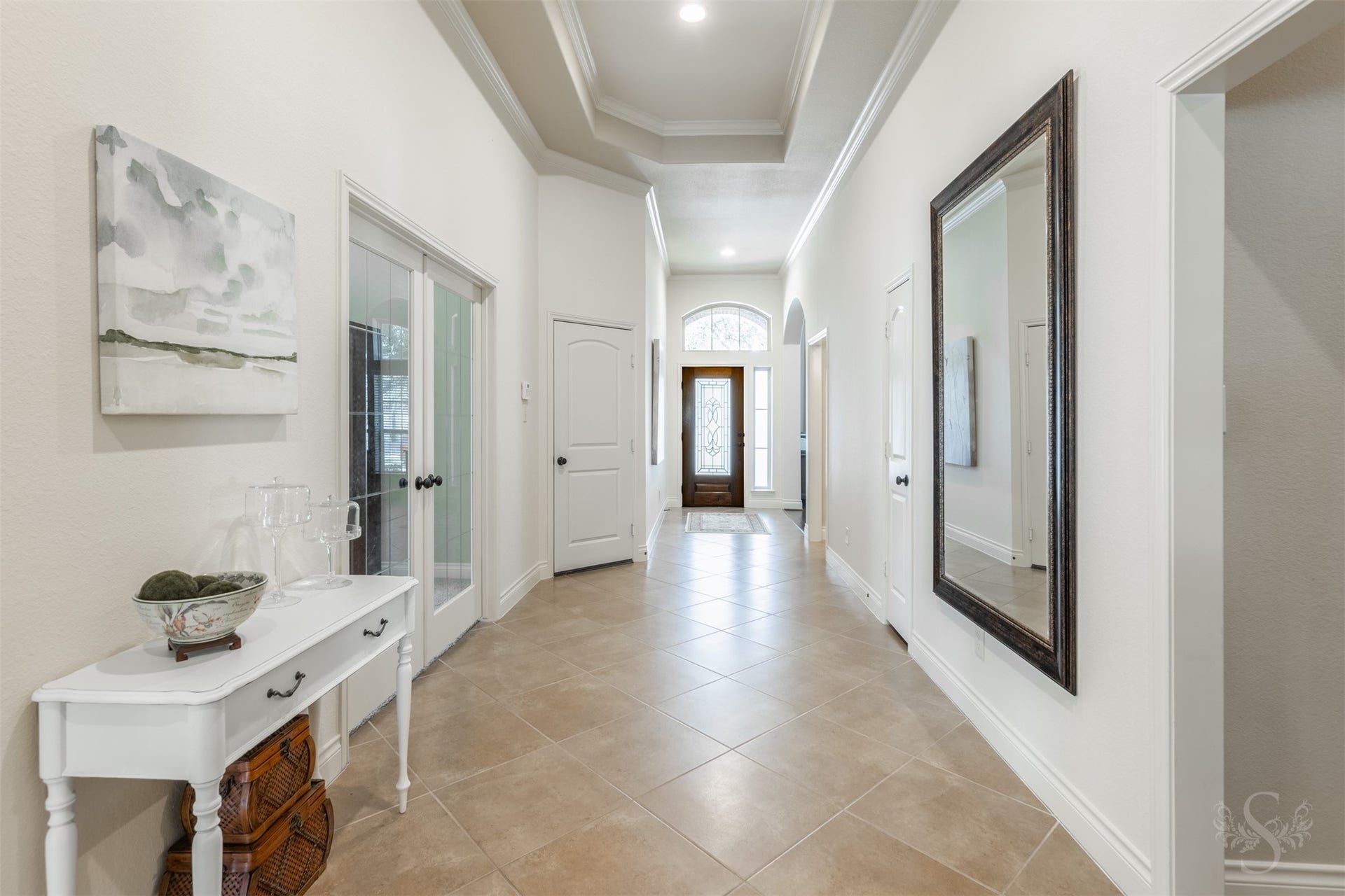 5219 Kenton Place Lane, Fulshear, TX 77441 An impressive tray ceiling edged in crown molding draws the eye along the extended entry, showcasing the homes exquisite architectural detail. Diagonally laid tile and graceful arched openings create an elegant passage toward the main gathering spaces.