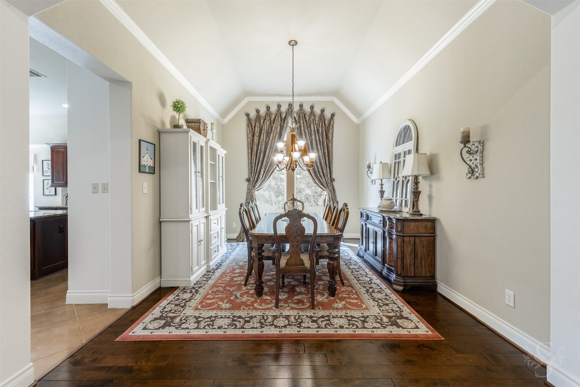 5219 Kenton Place Lane, Fulshear, TX 77441 Rich wood flooring and a lofty ceiling outlined in crown molding create an elegant setting in the formal dining room. A graceful chandelier and tall window enhance this inviting space for memorable dinners and entertaining friends.