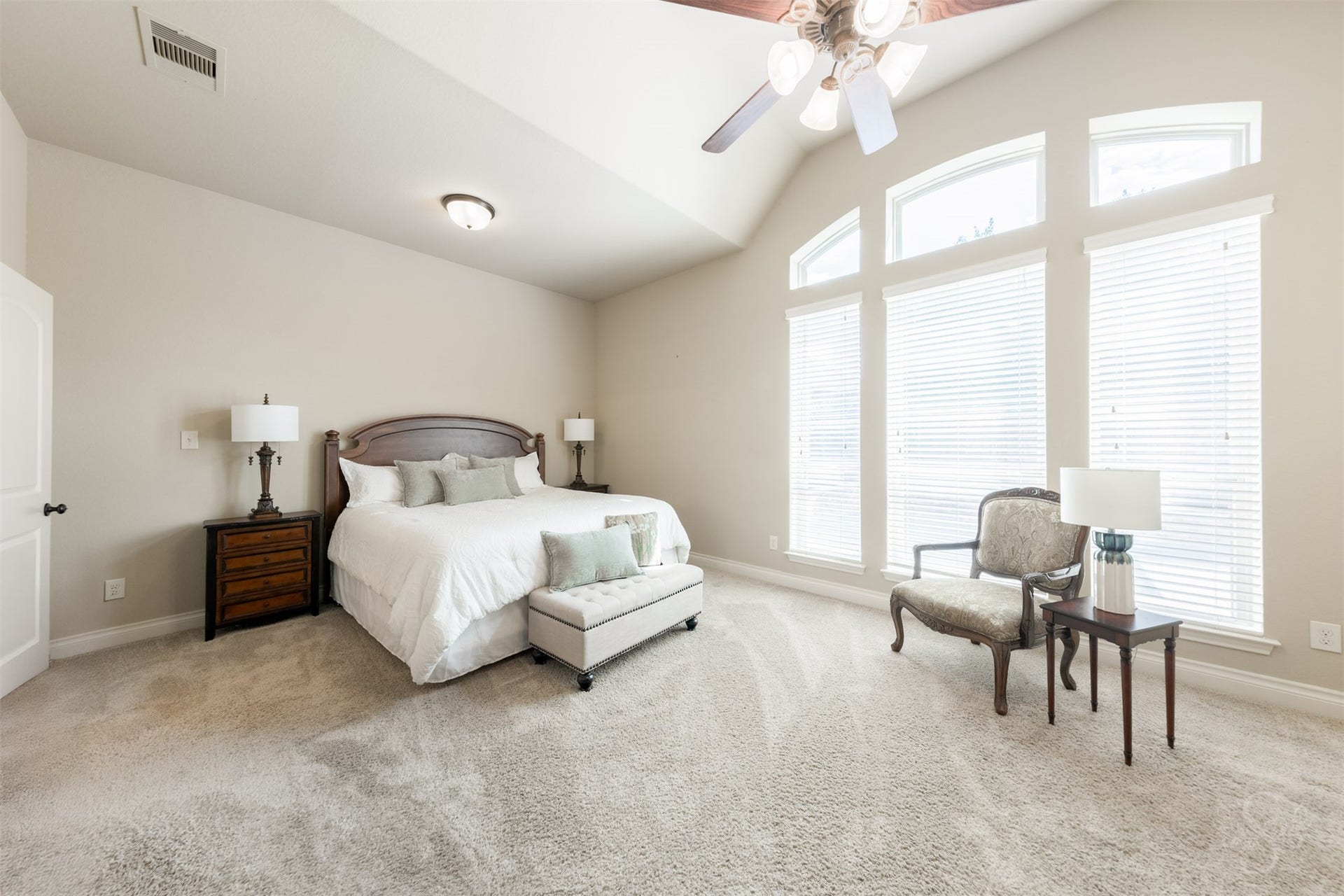 5219 Kenton Place Lane, Fulshear, TX 77441 A stunning 12-foot gabled ceiling and expansive windows create an elegant retreat in the spacious primary suite. Generous proportions allow for a comfortable sitting area, perfect for quiet reading or unwinding at the end of the day.