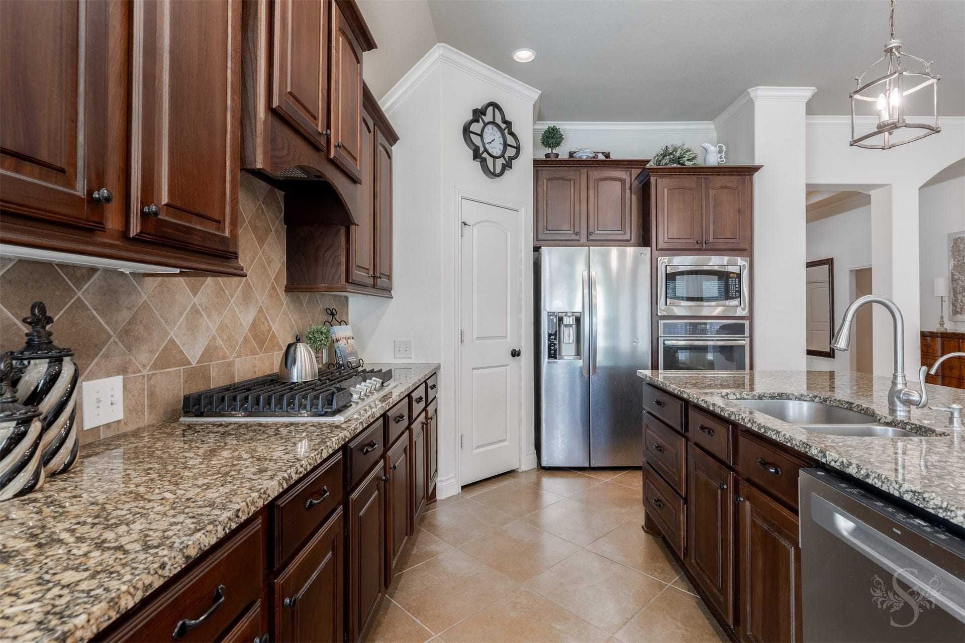 5219 Kenton Place Lane, Fulshear, TX 77441 Richly stained 42-inch raised panel cabinetry and polished granite countertops bring timeless elegance to the spacious kitchen. A gas cooktop, built-in stainless steel oven and microwave, and generous island workspace make preparing family favorites and entertaining a pleasure.