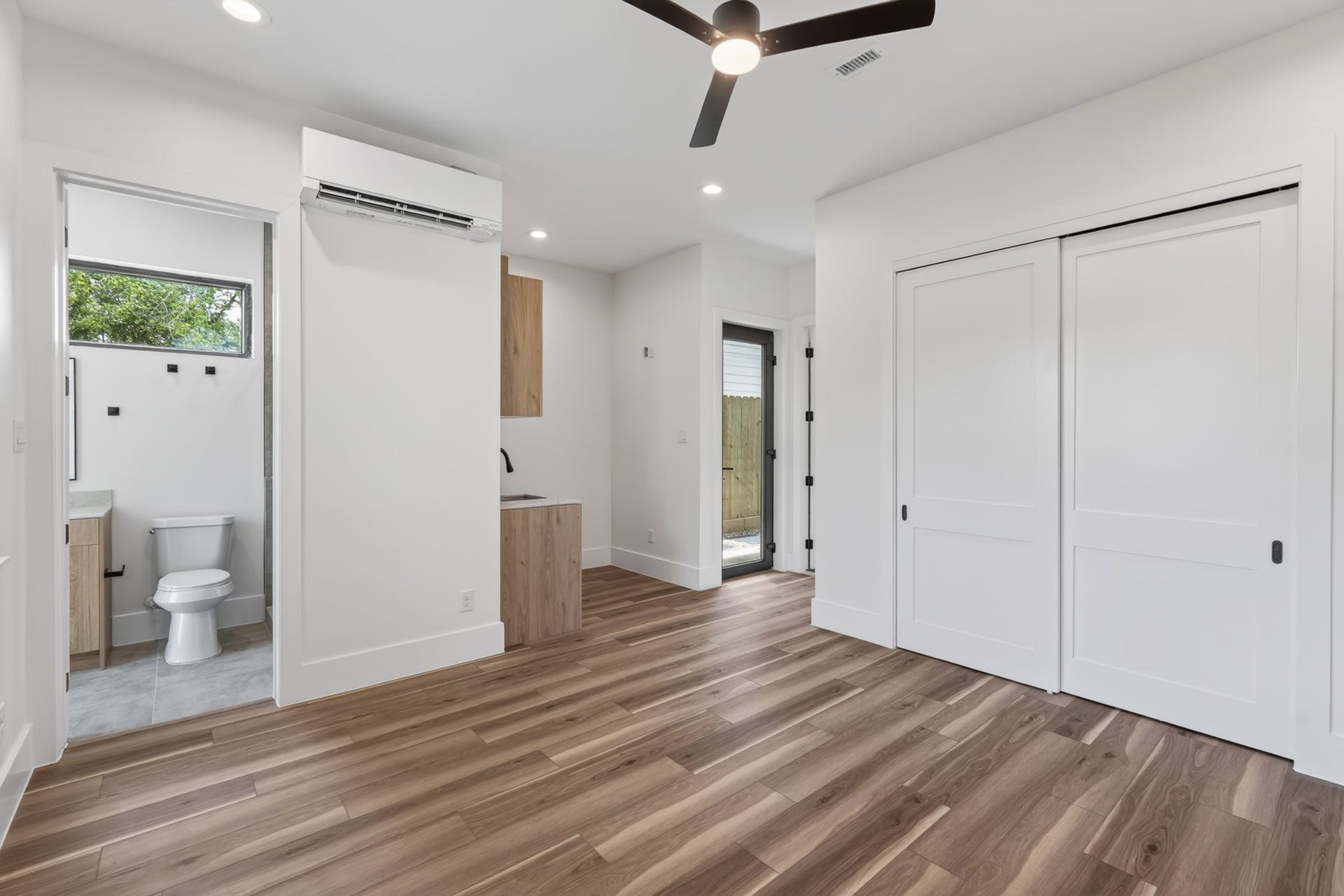 Comfortable guest bedroom with generous windows, ample closet space, a convenient kitchenette, and a versatile layout with a private entrance, offering excellent flexibility for guests, multigenerational living, or potential rental income.