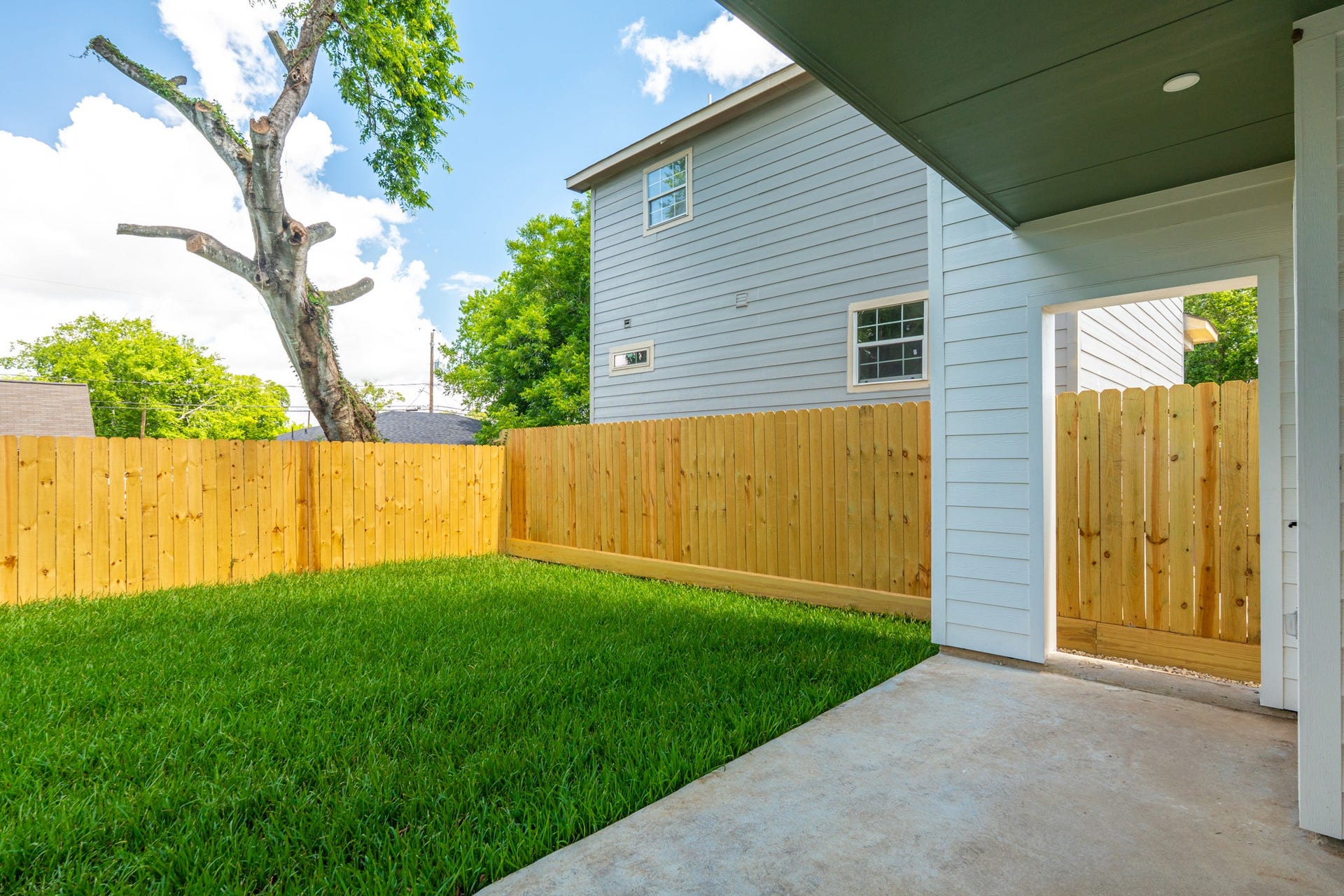 Spacious backyard featuring a covered patio, creating the ideal setting for outdoor dining, gatherings, or simply enjoying Houston's year-round climate.