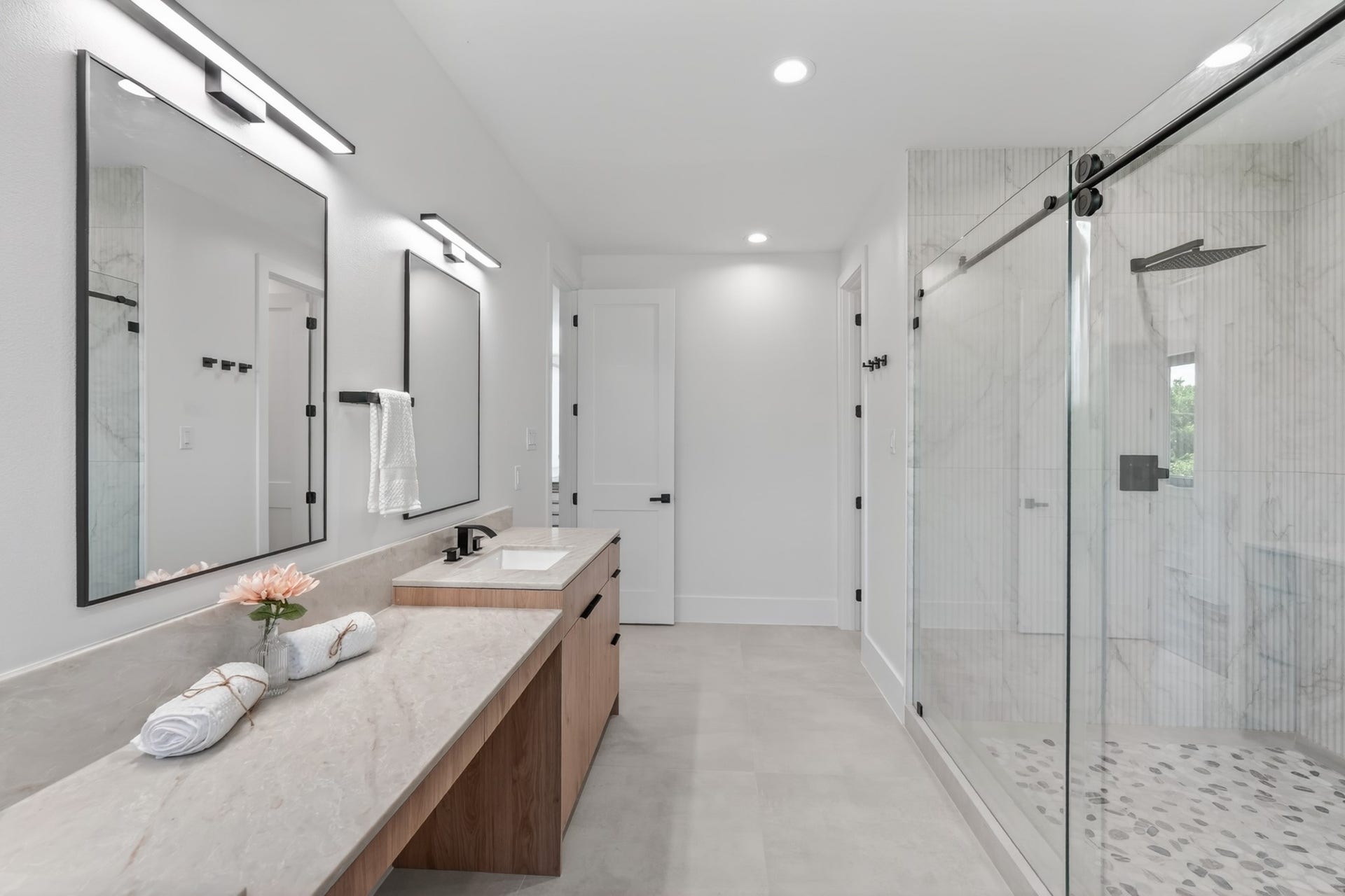 Spa-inspired primary bathroom with his-and-hers vanities, a dedicated makeup station, a large walk-in shower, a separate soaking tub, and beautiful natural light.