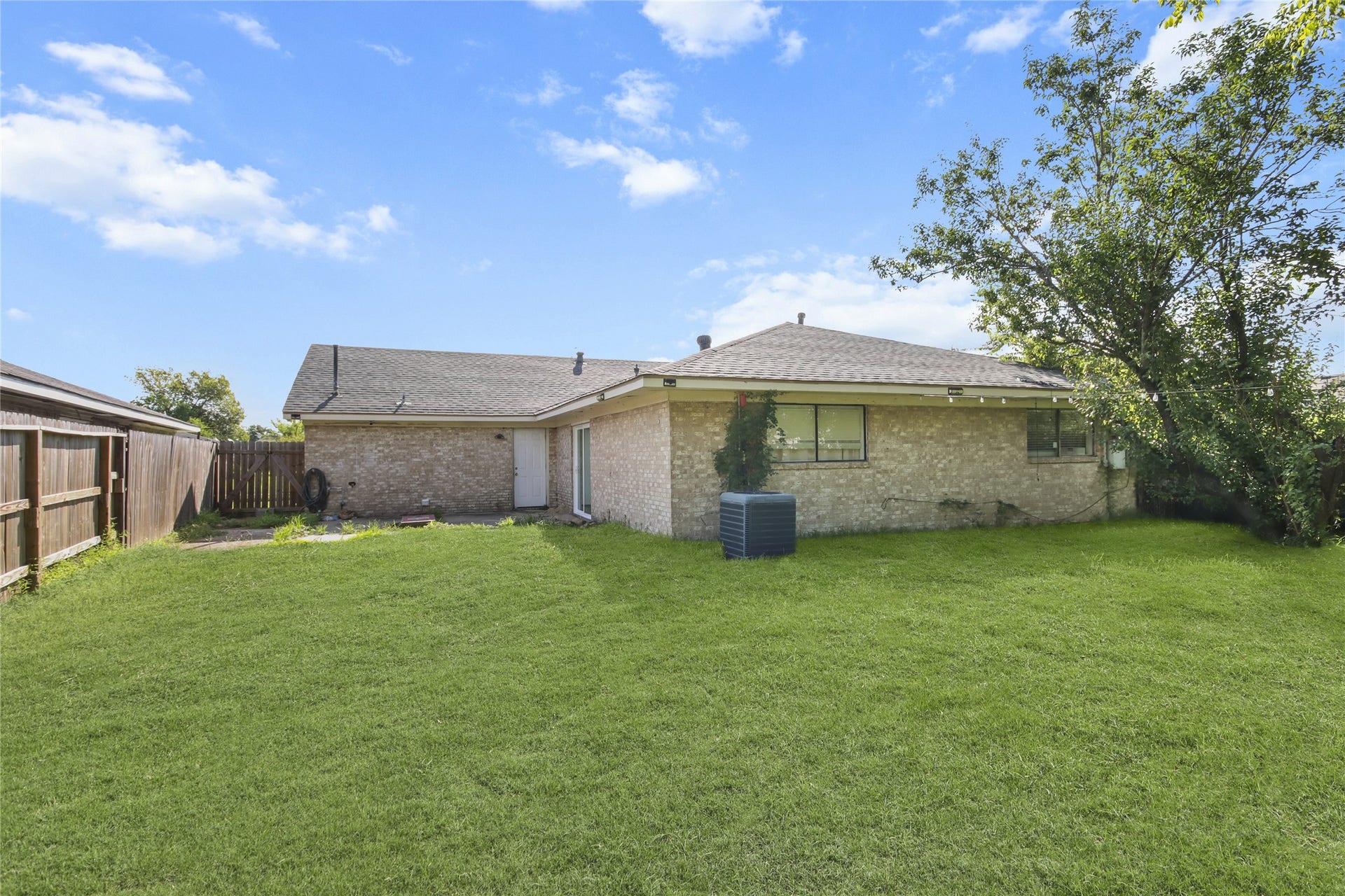 910 Centerwood Drive, Houston, TX 77013 The spacious backyard offers plenty of green space and a wood privacy fence, with string lighting for evening ambiance. Both the back door and sliding glass door provide easy access between the home and the spacious backyard.