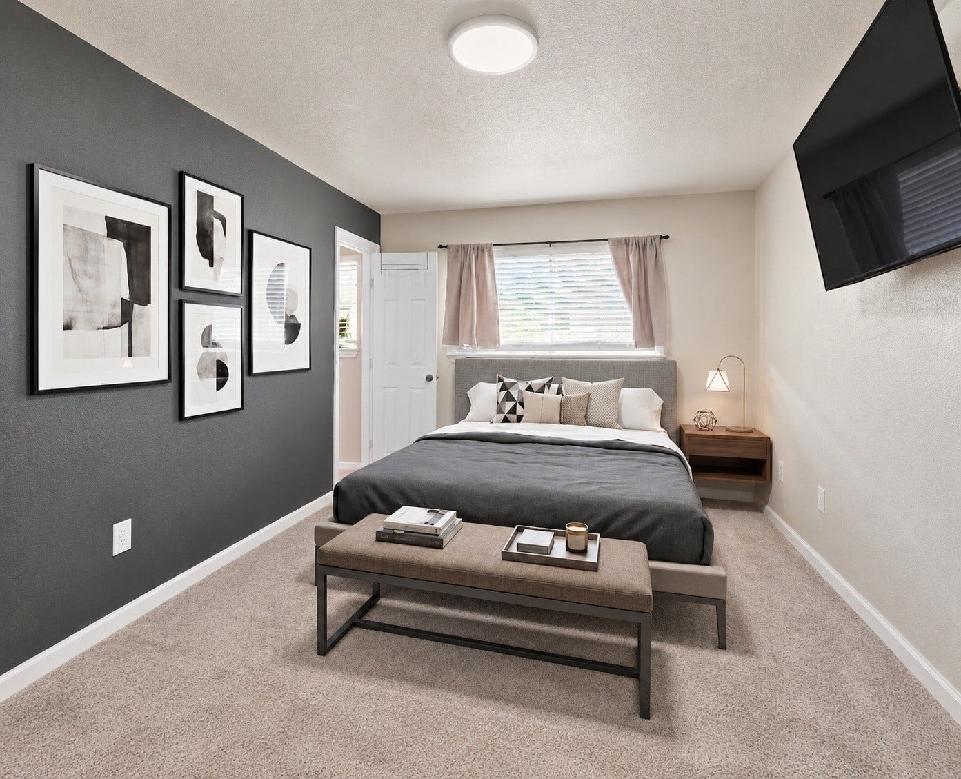910 Centerwood Drive, Houston, TX 77013 The primary bedroom offers a bold accent wall, plush carpet, and a large window for natural light. Virtually staged.