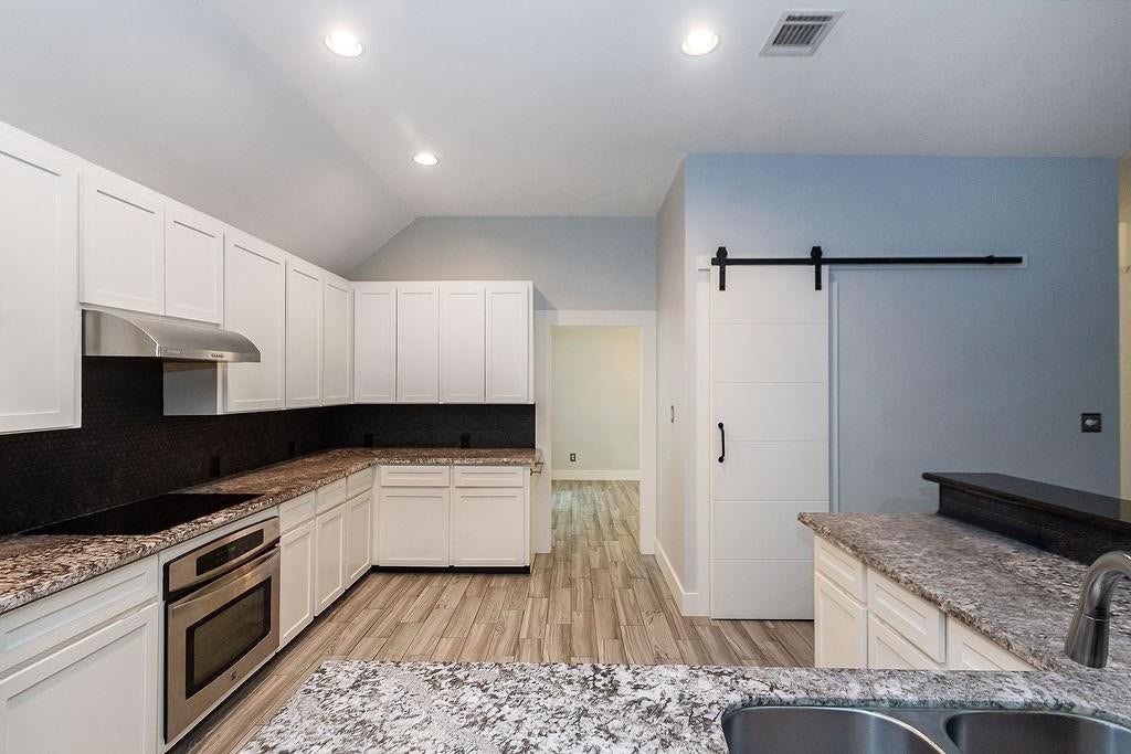 Large counter tops with lots of cabinets make this kitchen very functional. Large pantry gives this kitchen everything