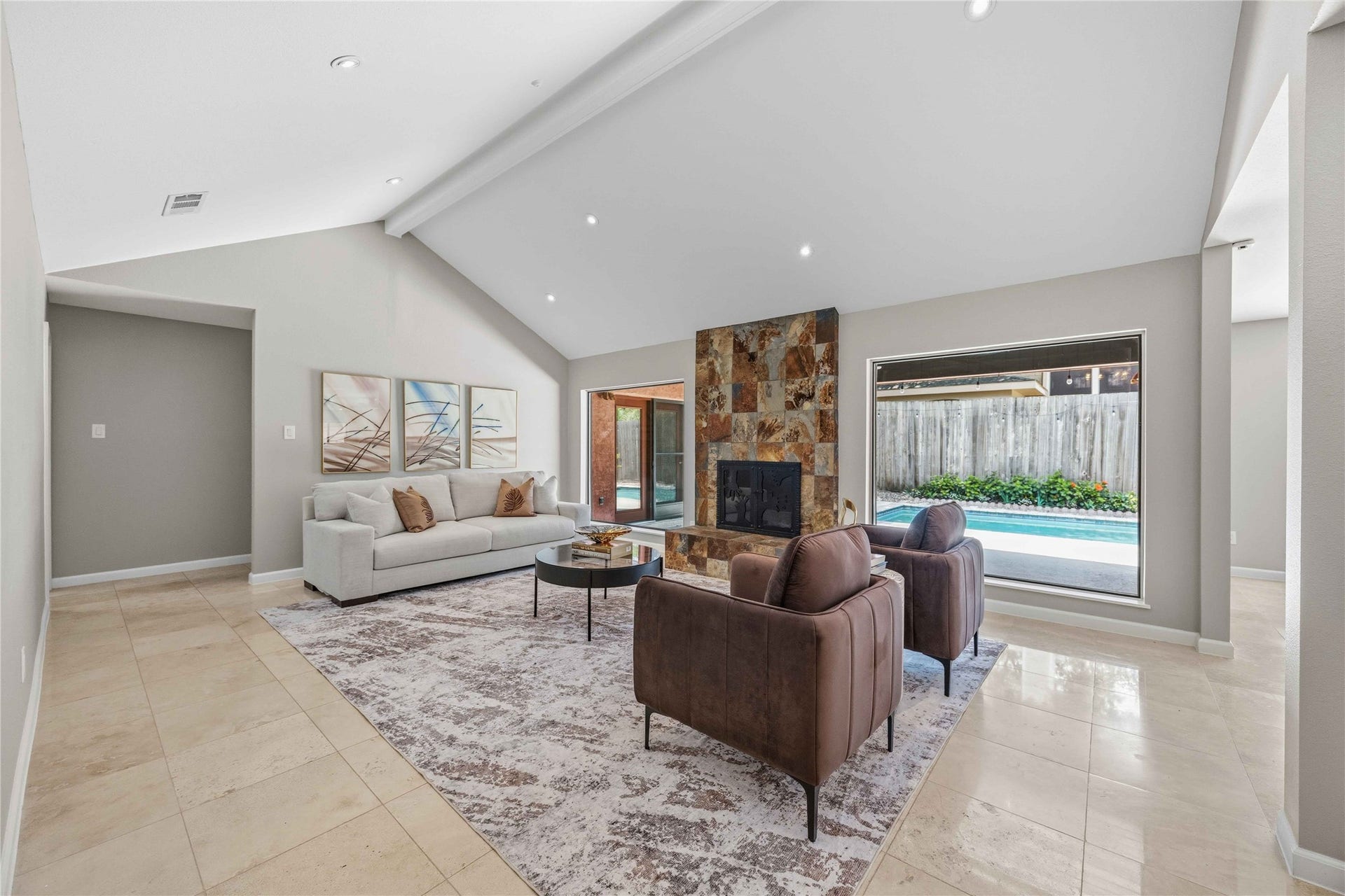 619 Rancho Bauer Drive, Houston, TX 77079 An inviting first impression begins with soaring vaulted ceilings, expansive windows framing sparkling pool views, and a dramatic floor-to-ceiling stone fireplace that instantly makes you feel at home.