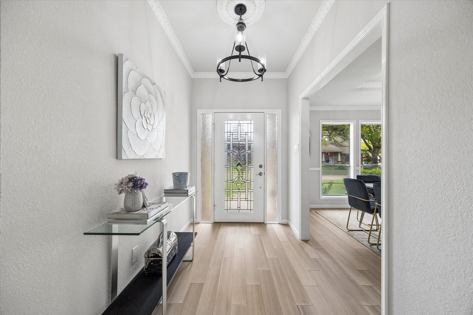 3122 Peach Tree Lane, Missouri City, TX 77459 This photo showcases a bright and welcoming entryway with light wood flooring and a decorative glass front door.
