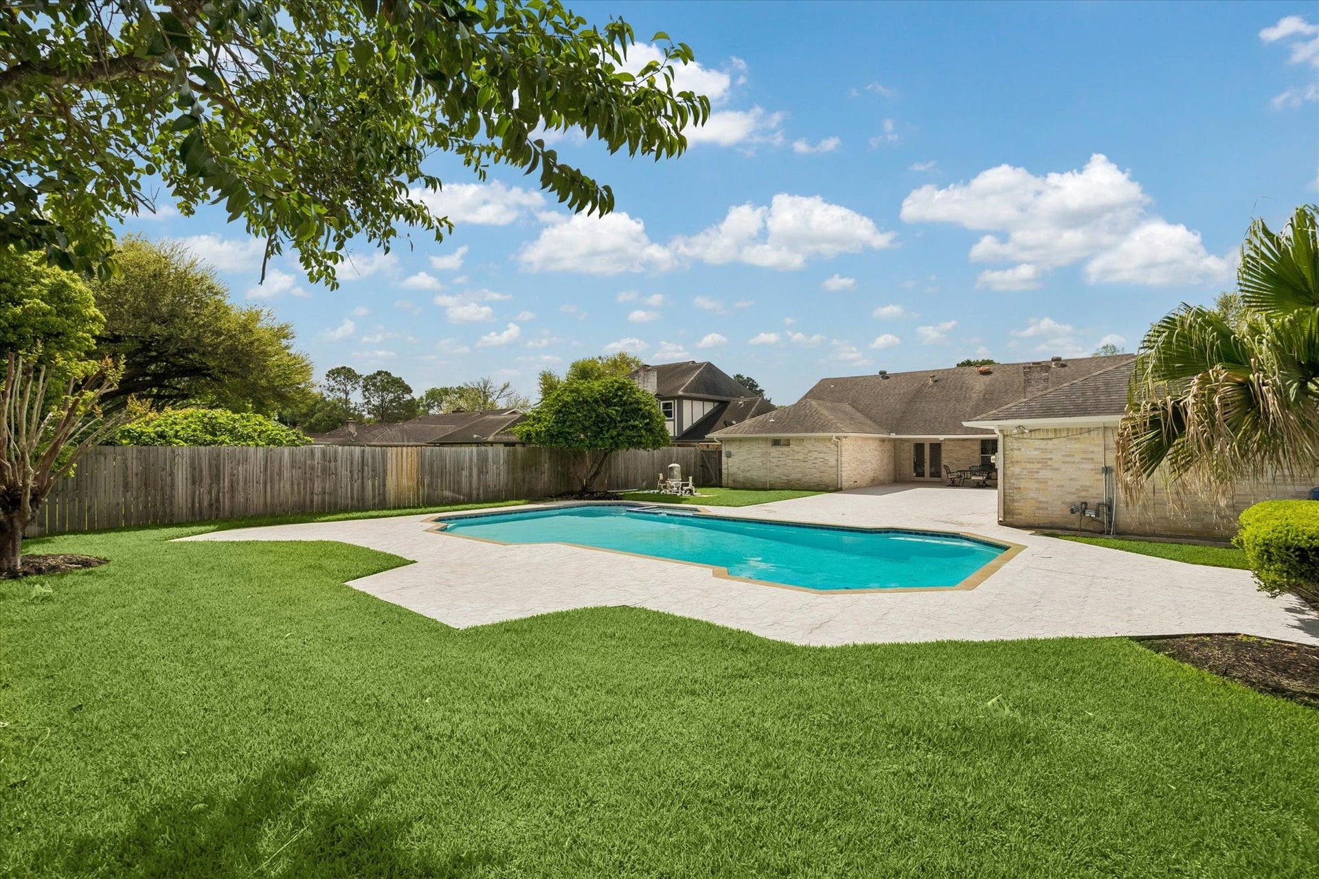 3122 Peach Tree Lane, Missouri City, TX 77459 Spacious backyard featuring a large swimming pool, well-maintained lawn, and privacy fencing, perfect for outdoor relaxation and entertainment.