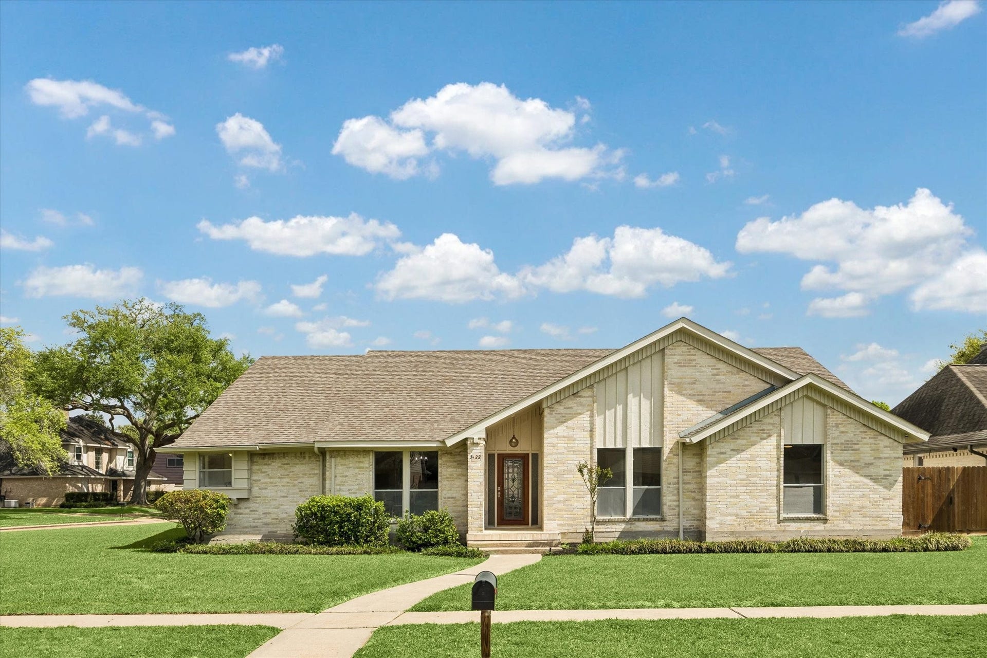 3122 Peach Tree Lane, Missouri City, TX 77459 This charming home features a light brick exterior with a gabled roof and a well-maintained front lawn. The symmetrical design includes large windows and a welcoming front entrance, creating an inviting curb appeal.