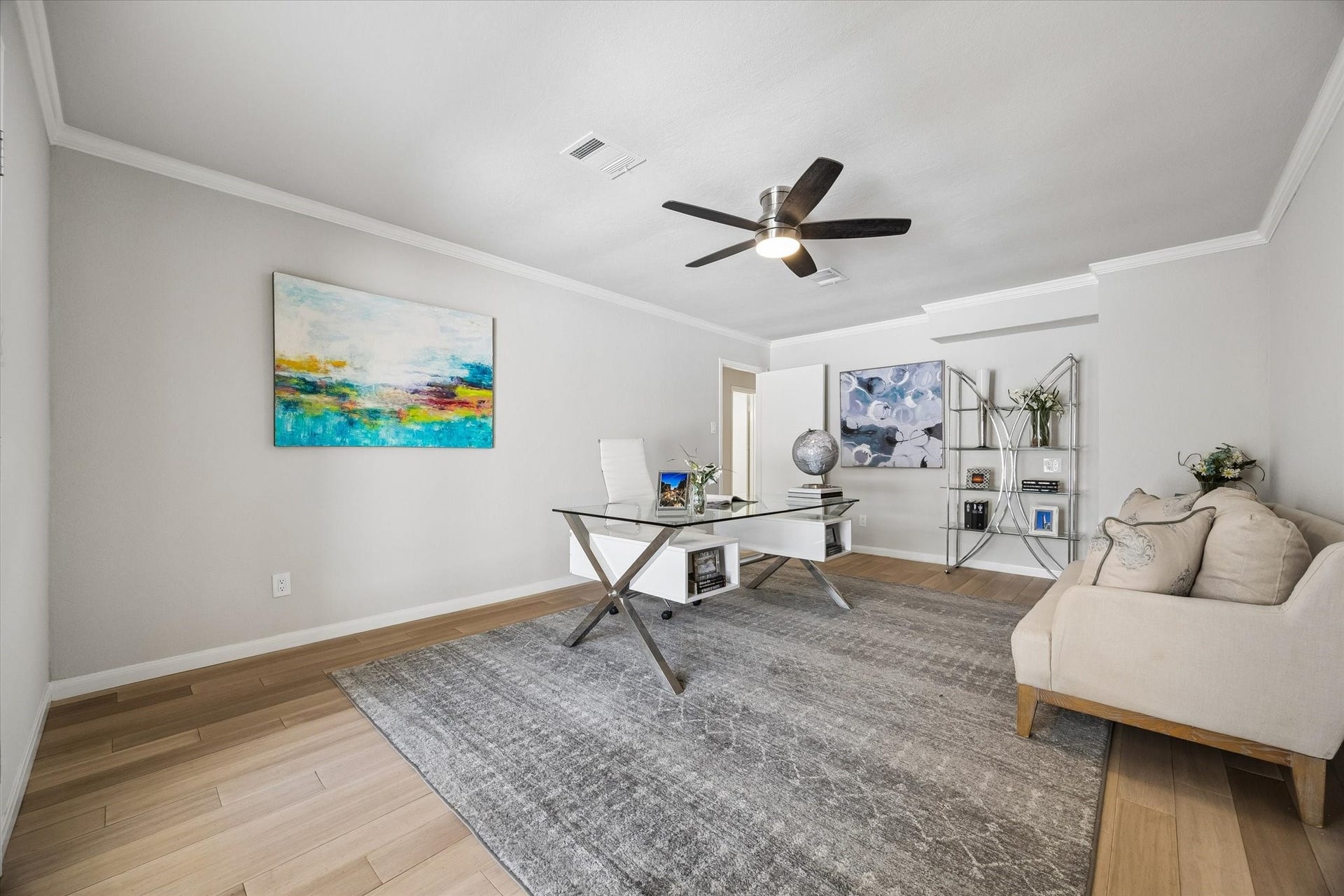 3122 Peach Tree Lane, Missouri City, TX 77459 This room is a stylish and spacious home office featuring a modern desk, comfortable seating, and elegant decor. It has light wood flooring, a large area rug, and ample natural light, creating a bright and inviting workspace.