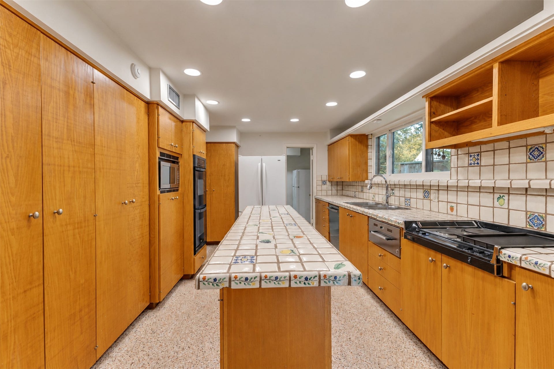 The kitchen has terrazzo floors and loads of storage.