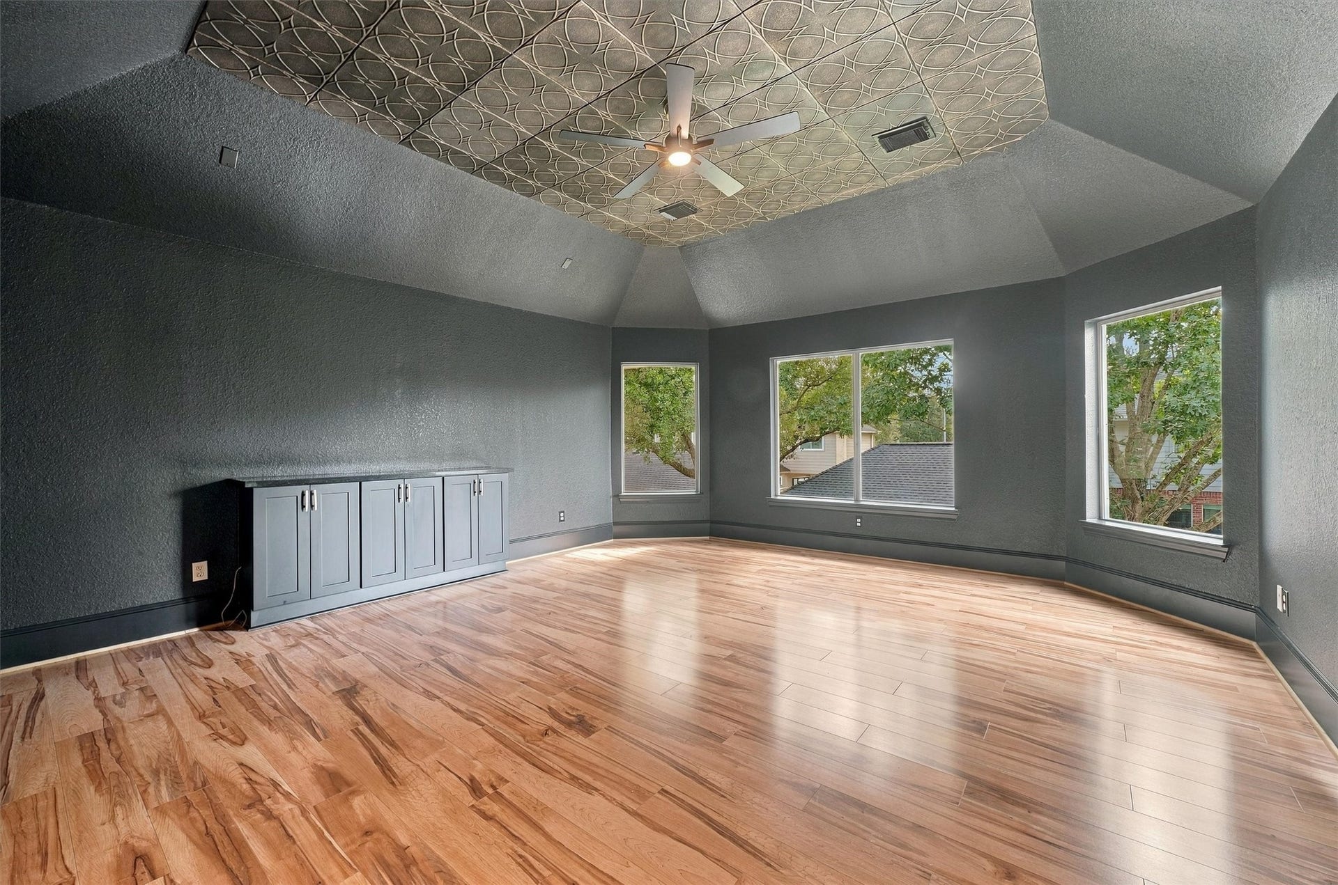 22415 Elizabeth Place Court, Katy, TX 77494 Media room or extra room located upstairs with decorative ceiling, ceiling fan, built-in cabinets, wood flooring, and large windows overlooking the treetops.