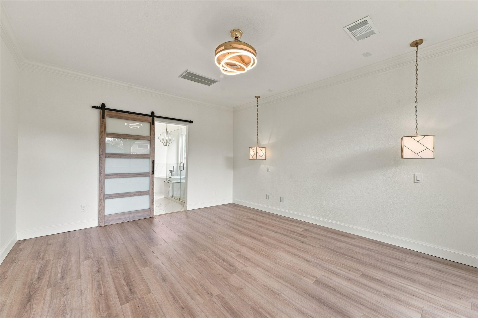 22415 Elizabeth Place Court, Katy, TX 77494 primary retreat
First-floor primary bedroom with wood flooring, sliding barn-style door, pendant lighting, and abundant natural light.